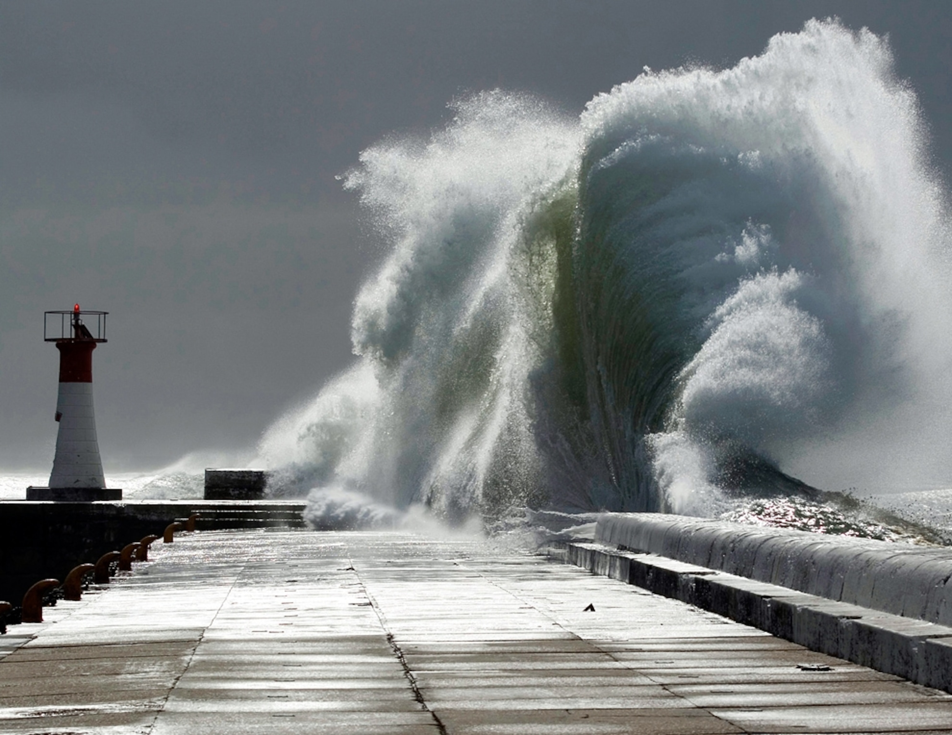 a huge wave crashing over a sea wall in South Africa