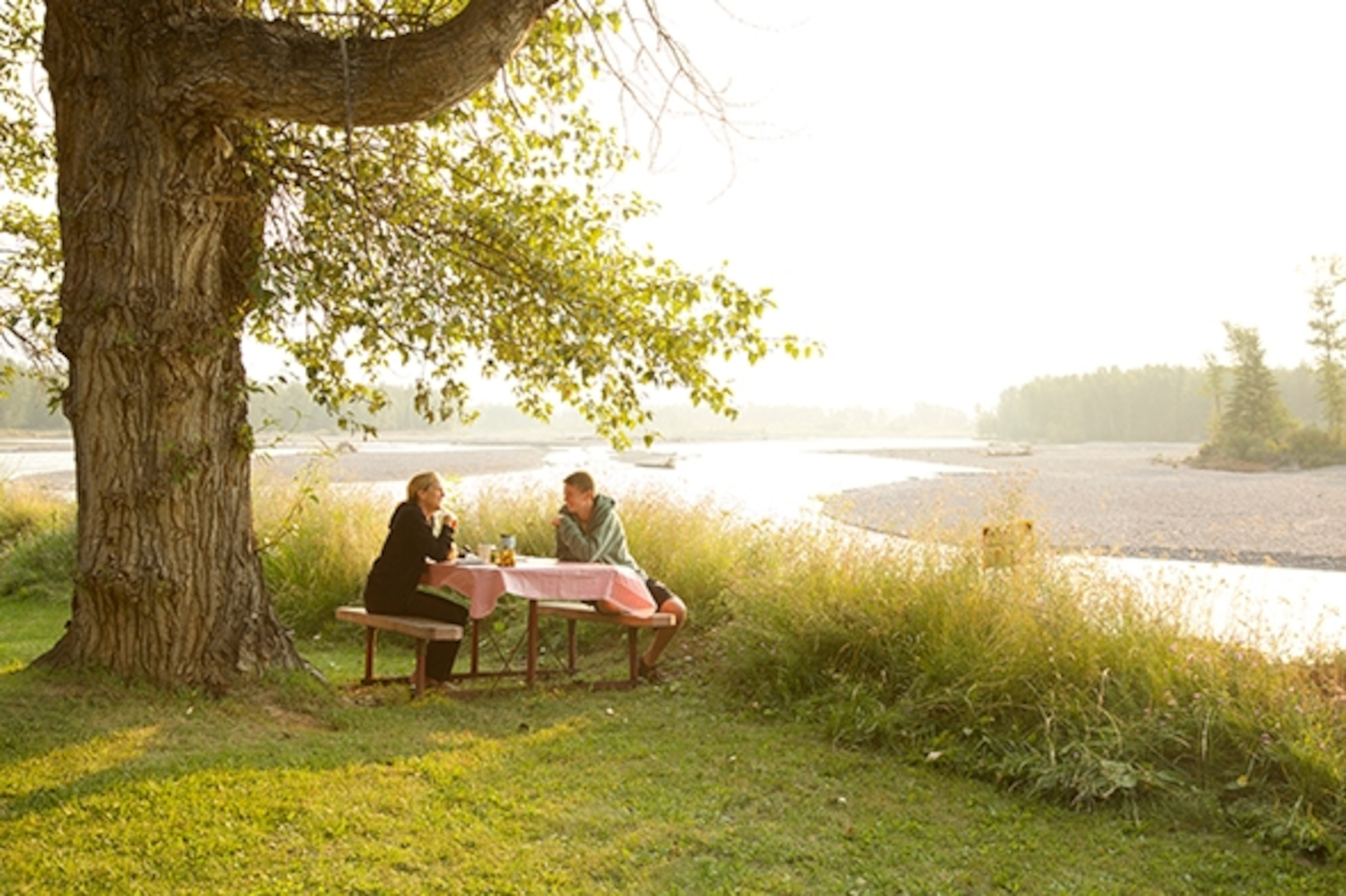 Jeb Kendrick and Jeannie Ralston have breakfeast outside camper on a table overlooking Flathead river. (Photograph by Rob Kendrick)