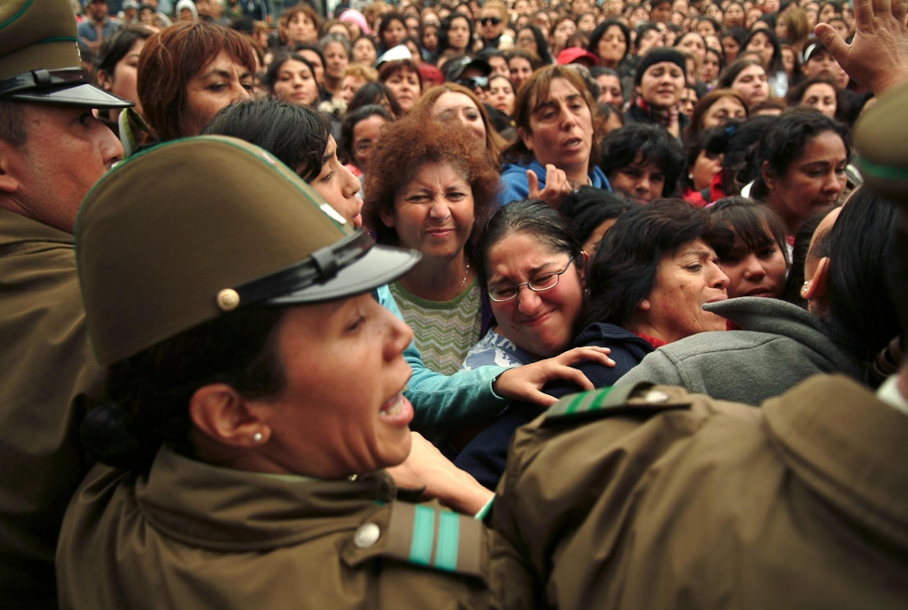 A picture shows Chilean police trying to hold back hungry residents following the Chile earthquake