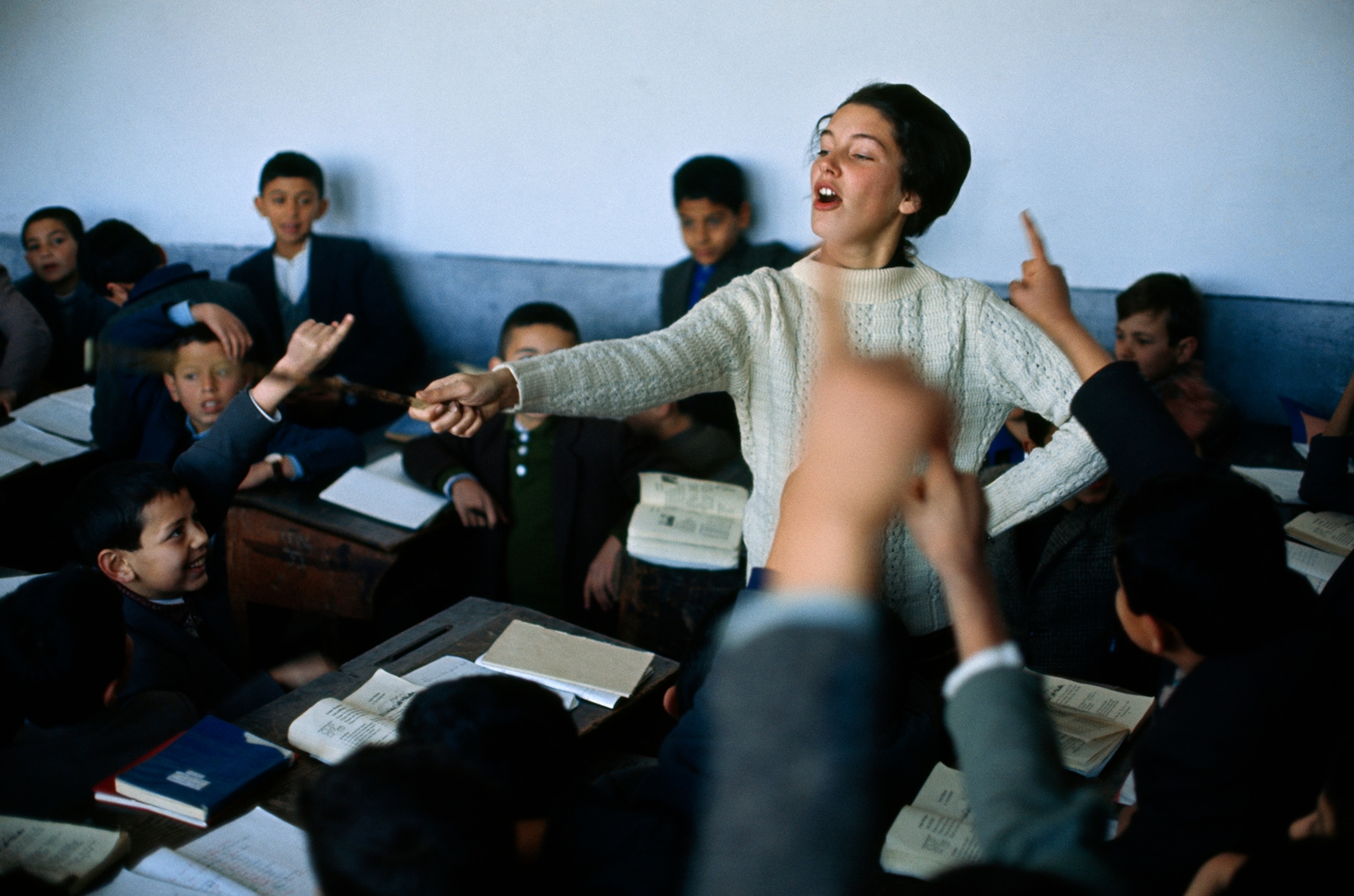 A Peace Corps volunteer teaches English to a classroom of boys in 1964.