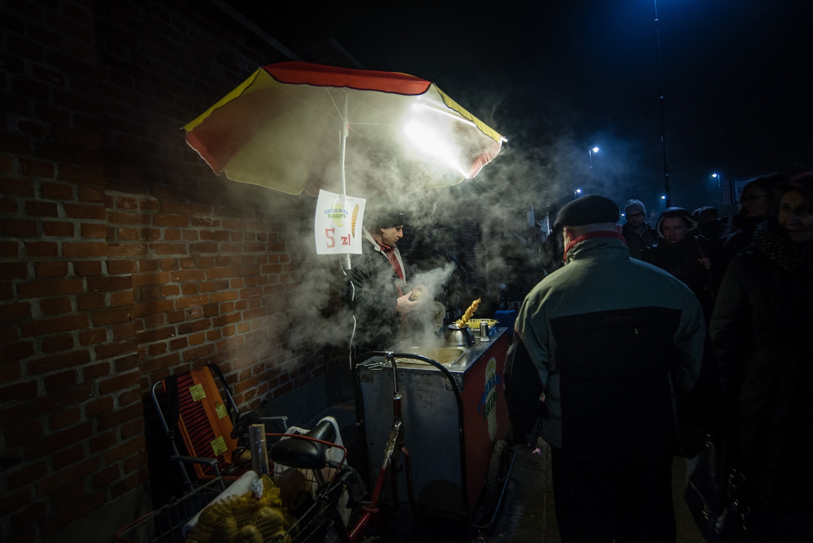 a man at his potato chips stand in Warsaw