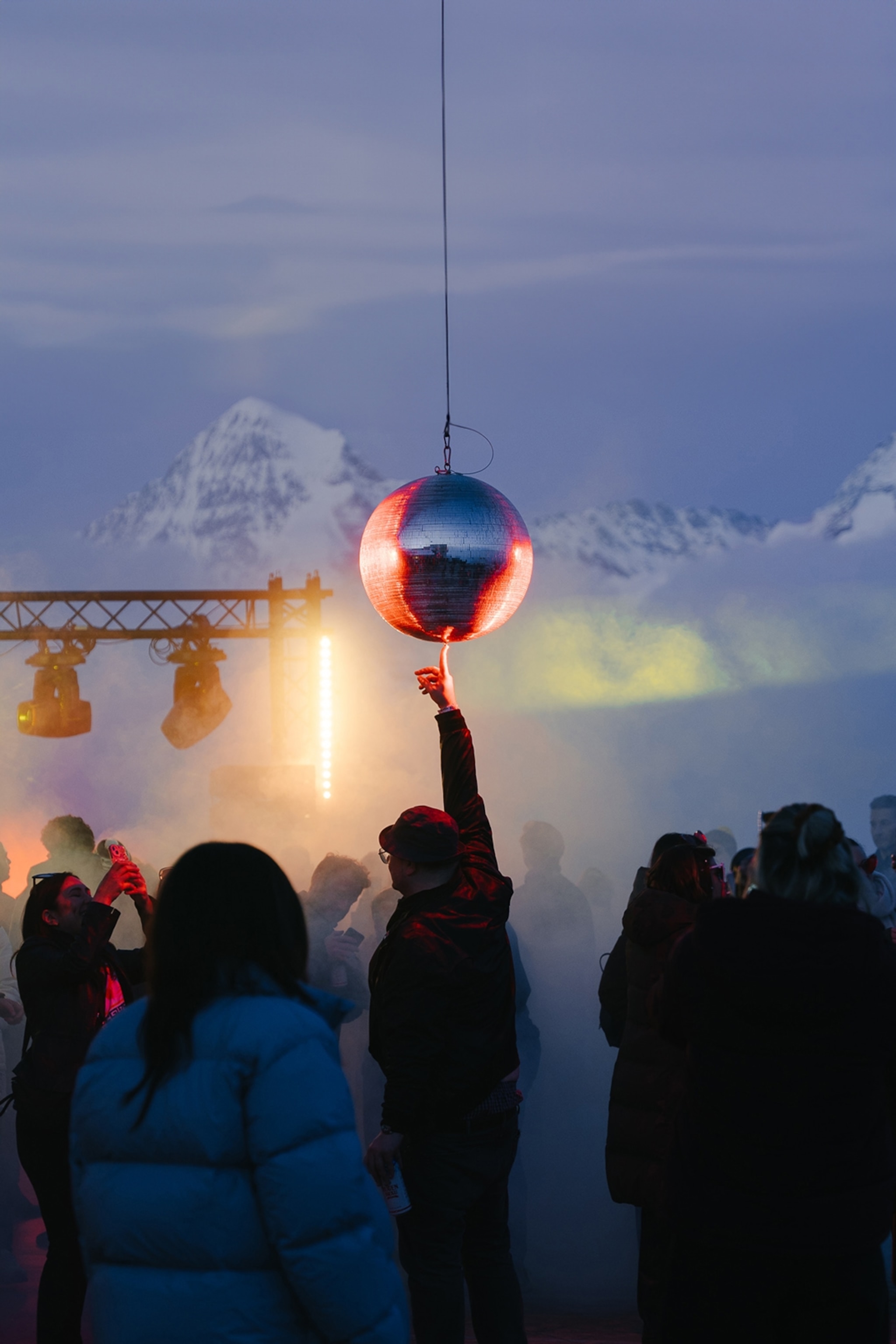 a man touching a disco ball at a rave