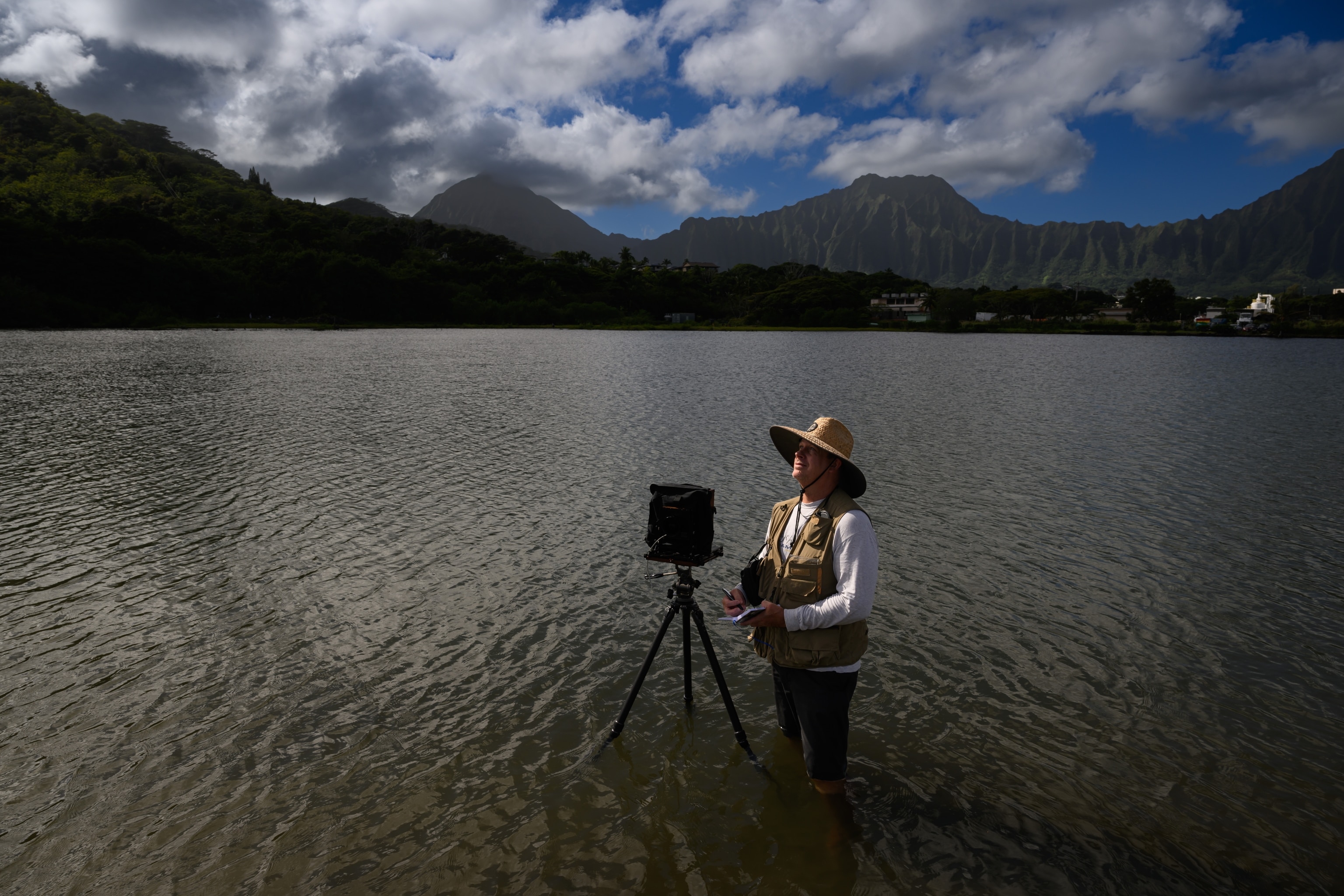 Photographer David Matt wades in the waters of Waikalua Loko Iʻa to capture the unique aquatic architecture of the fishpond and the boundary wall that separates it from the open ocean.