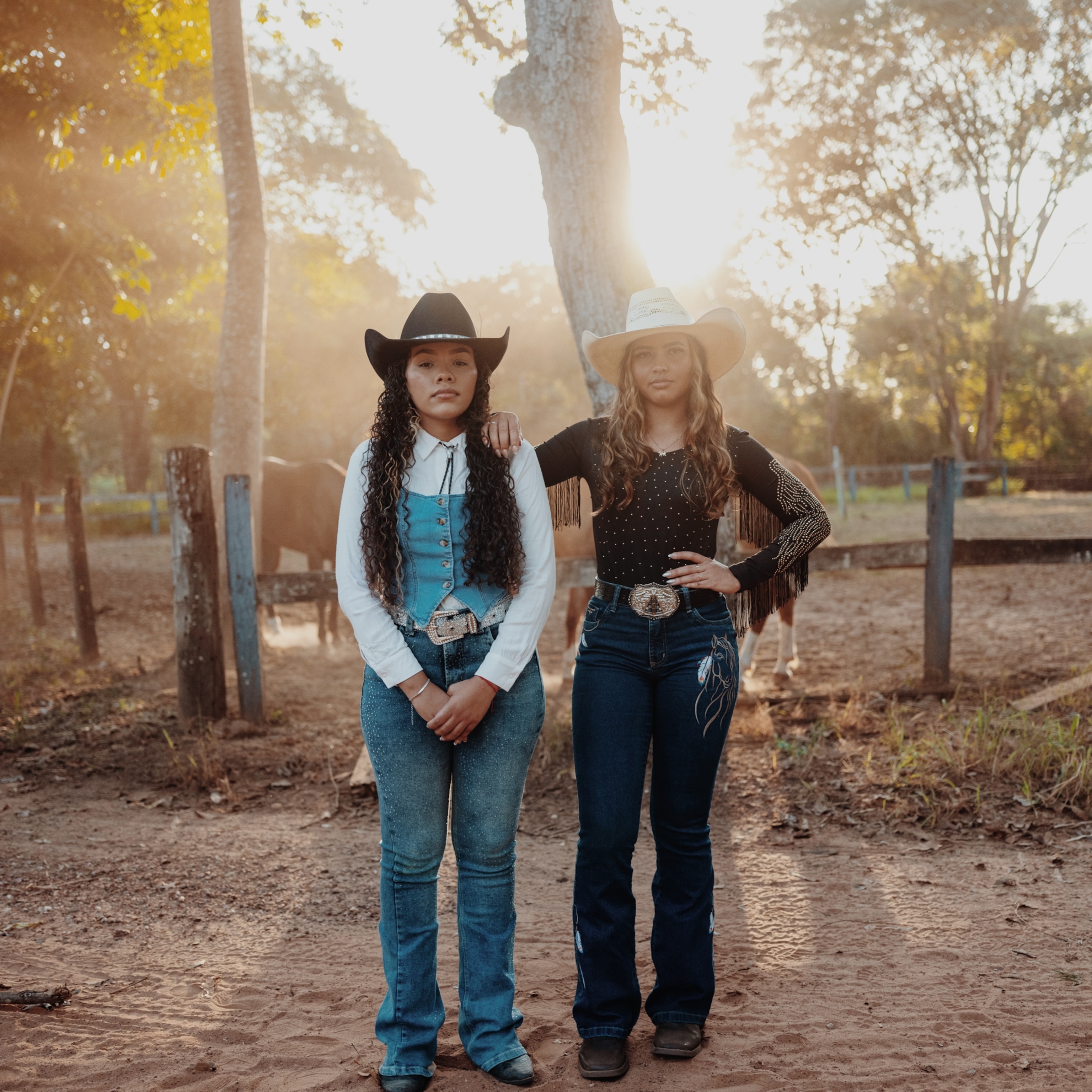 Two young girls wearing cowgirl hats and country outfits.