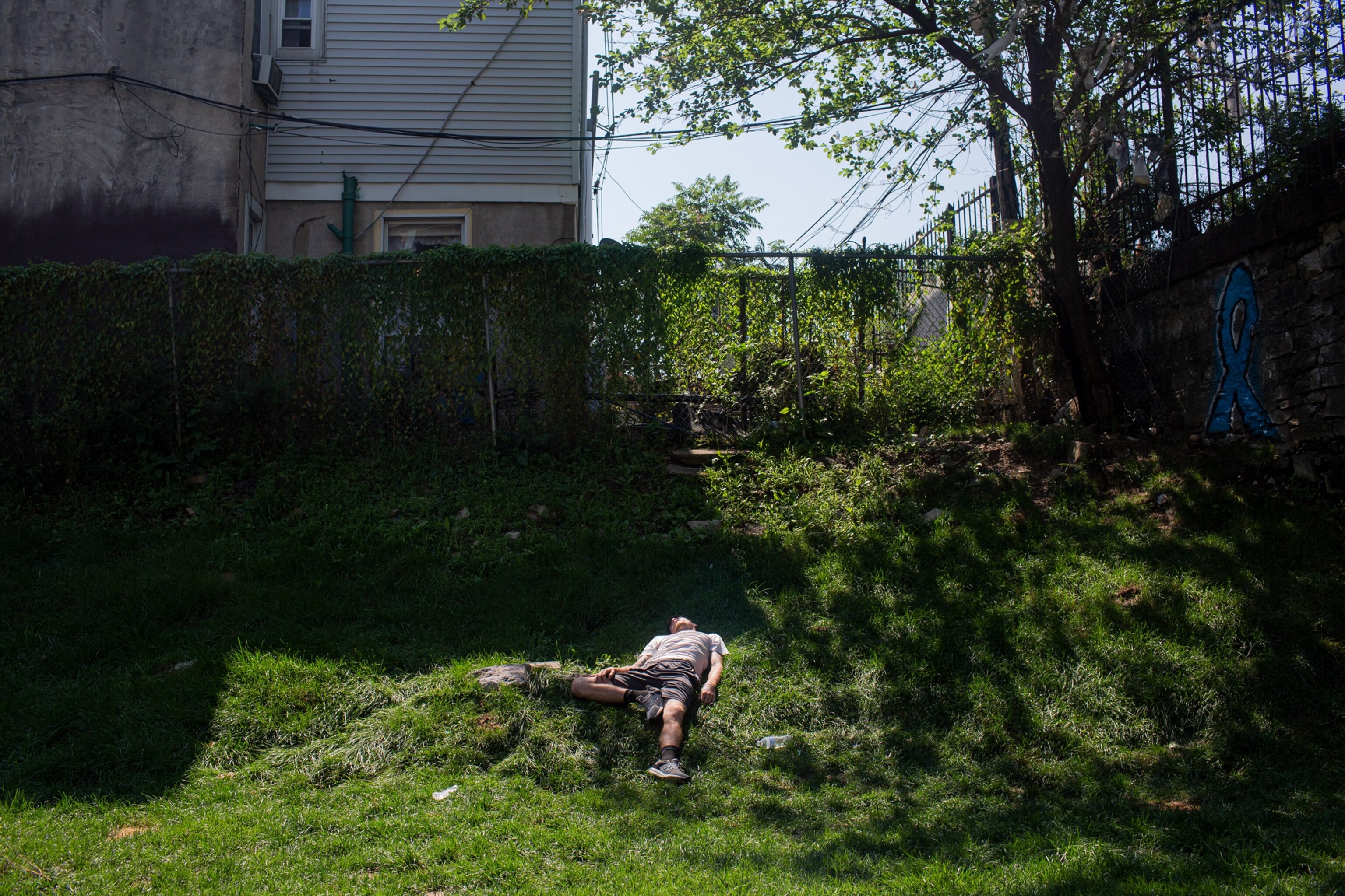 man laying on backyard grass