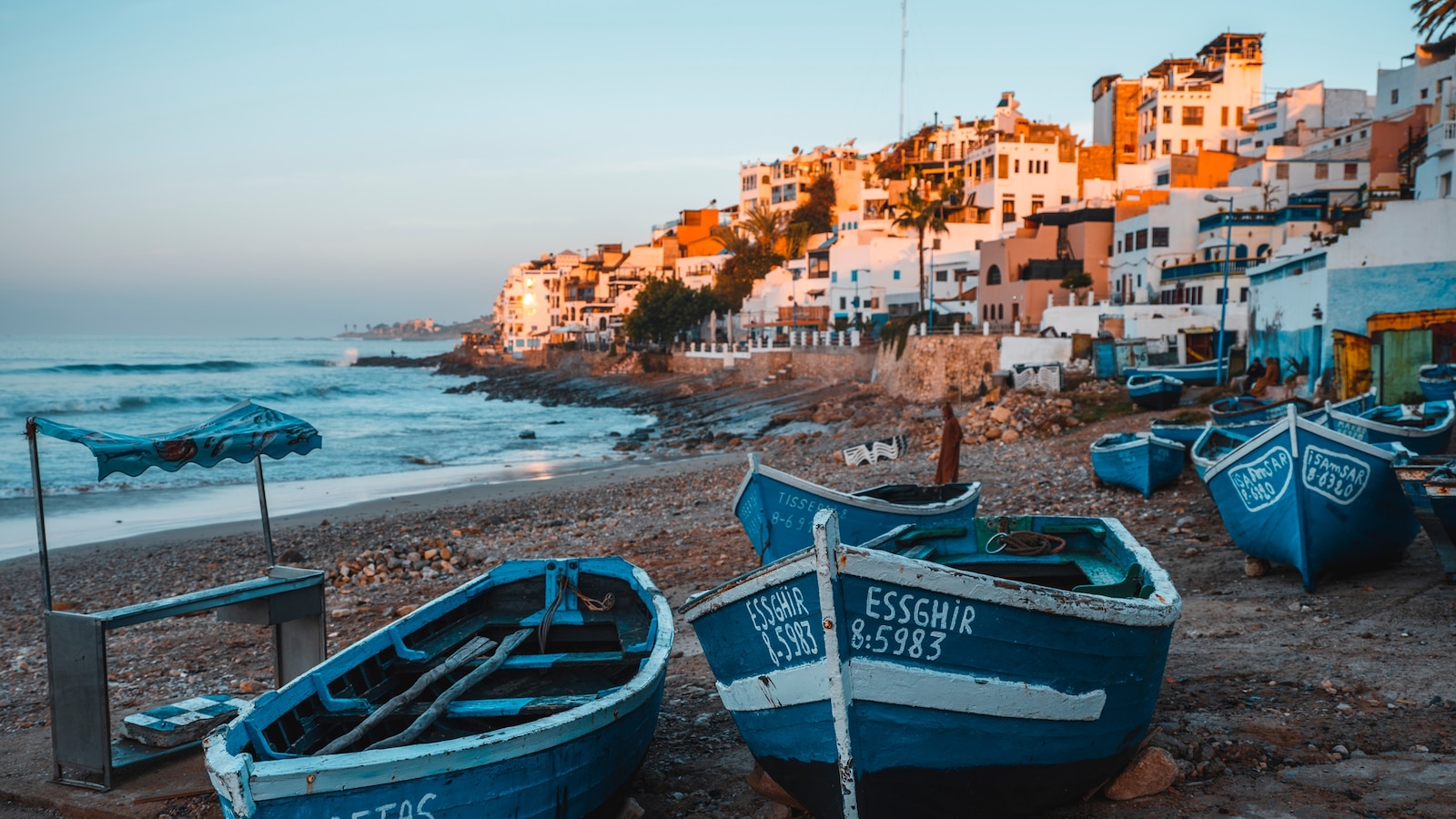 Aerial view of Taghazout village on the Moroccan coast with blue fishing boats