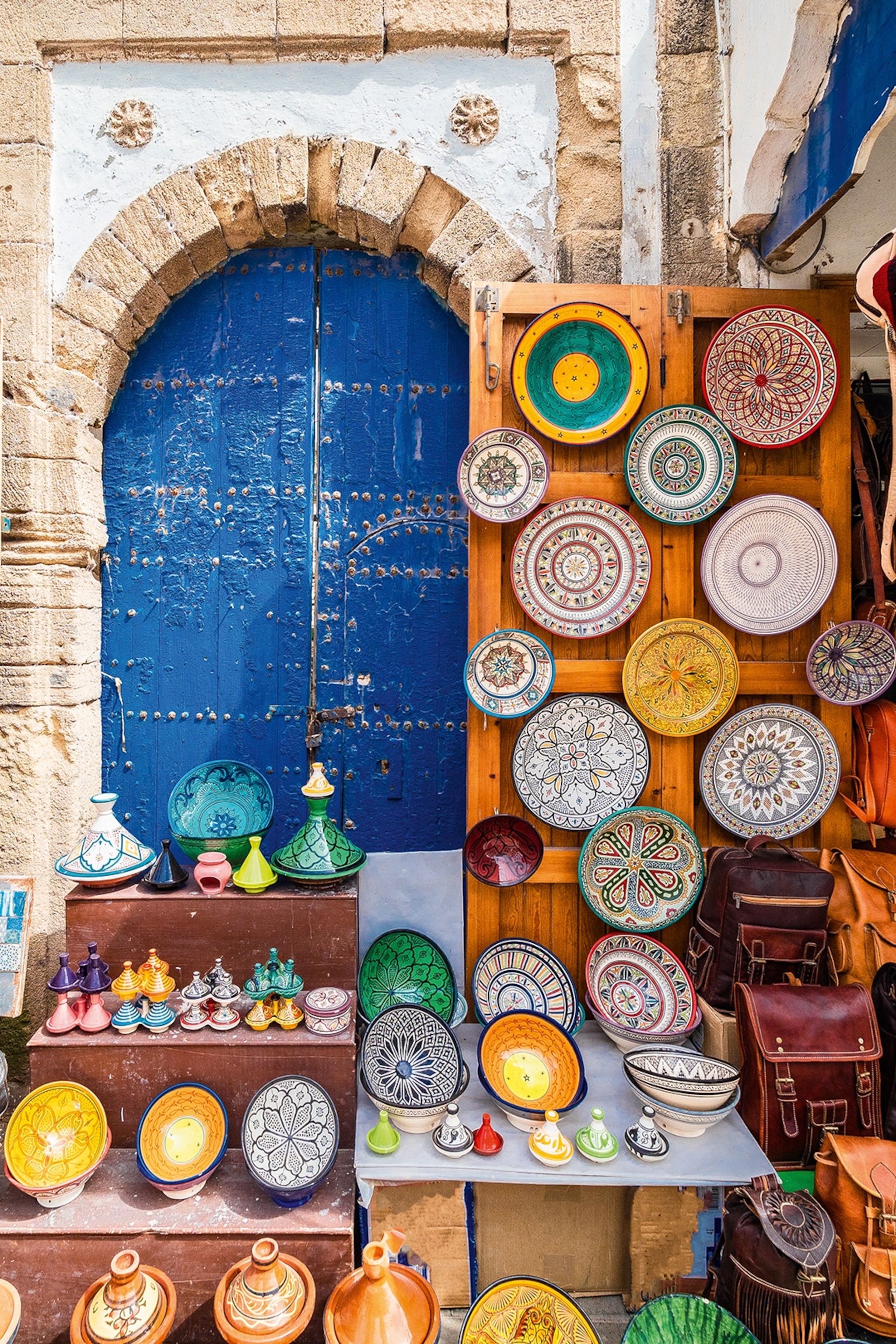 The outdoor set-up of a shop on a souk in Marrakech, selling various painted bowls and ceramics.