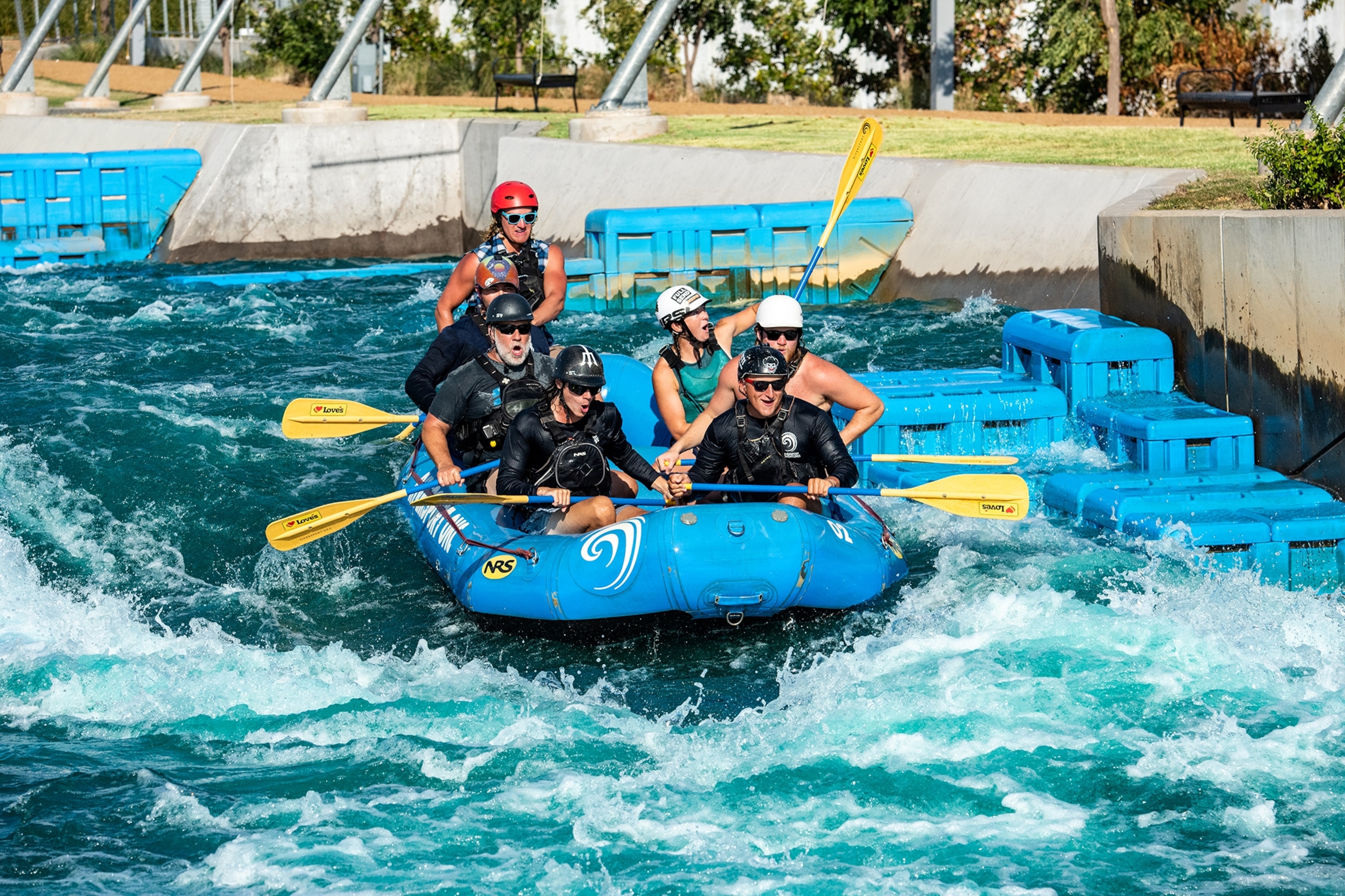 People in wetsuits paddle through the man-made whitewater rapids at Riversport in Oklahoma City.