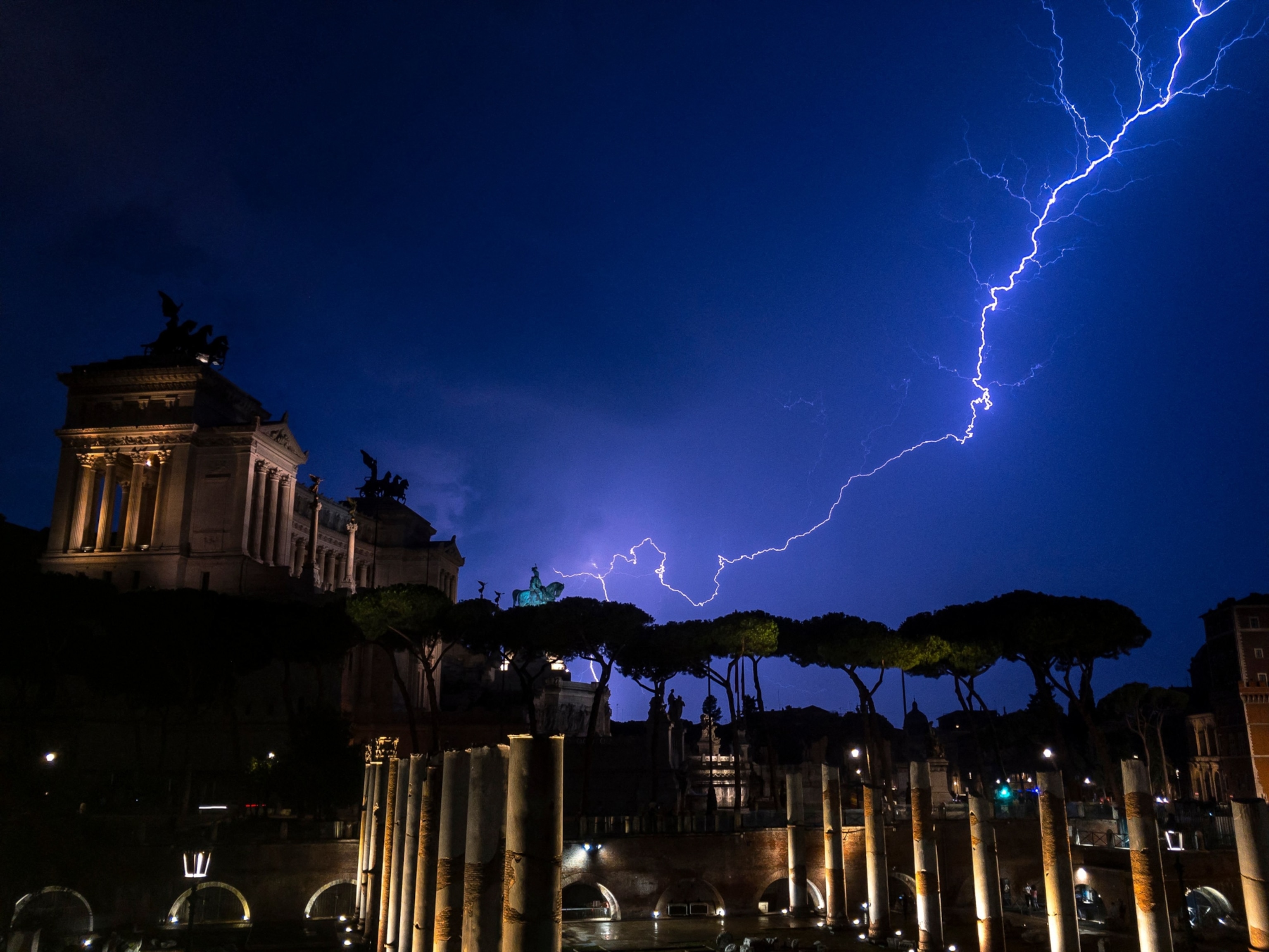 A lightning strikes over the Vittorio Emanuele II monument and its equestrian statue in Rome during a thunderstorm.