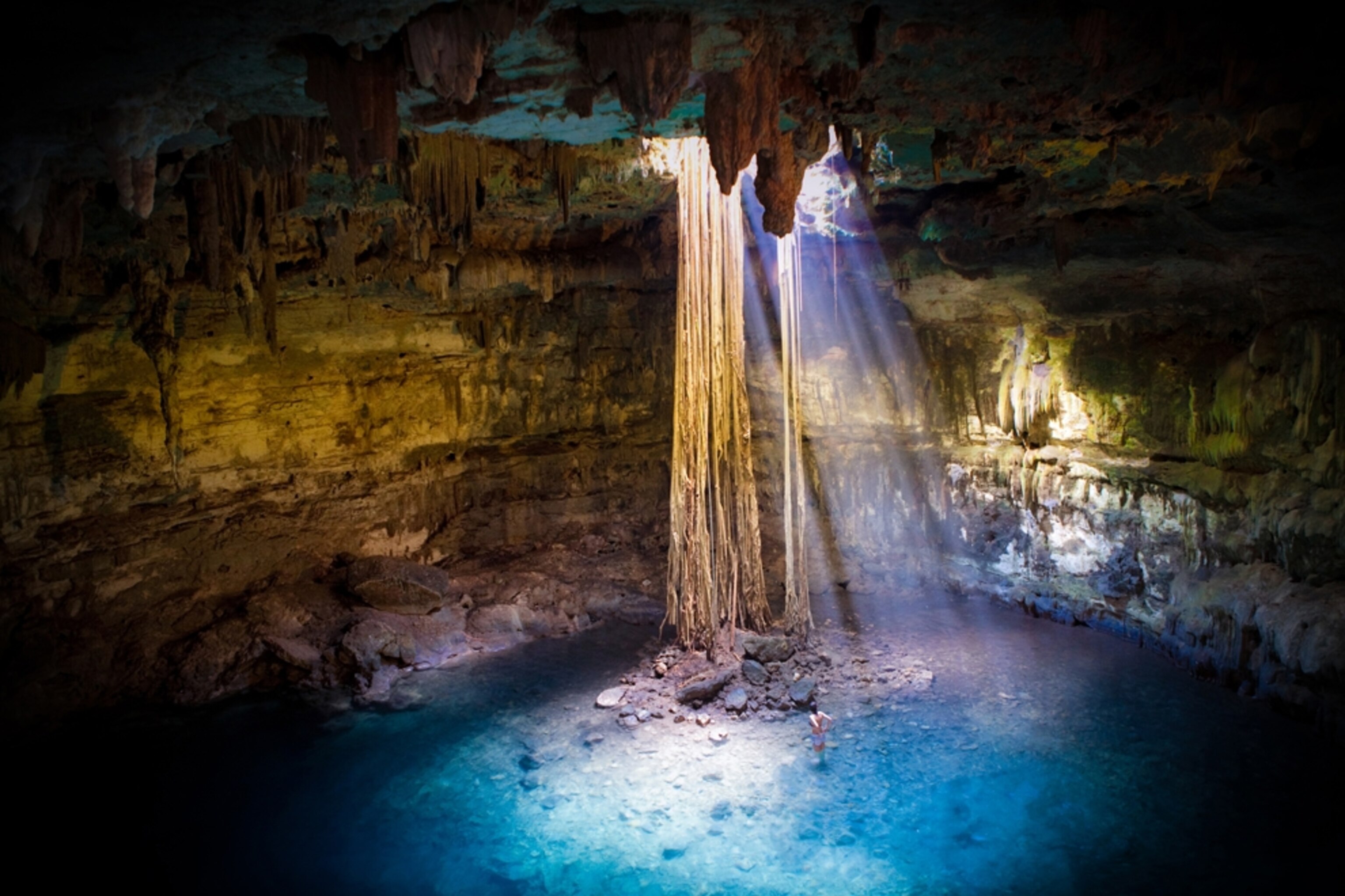 Woman stands in the water in a pool of light