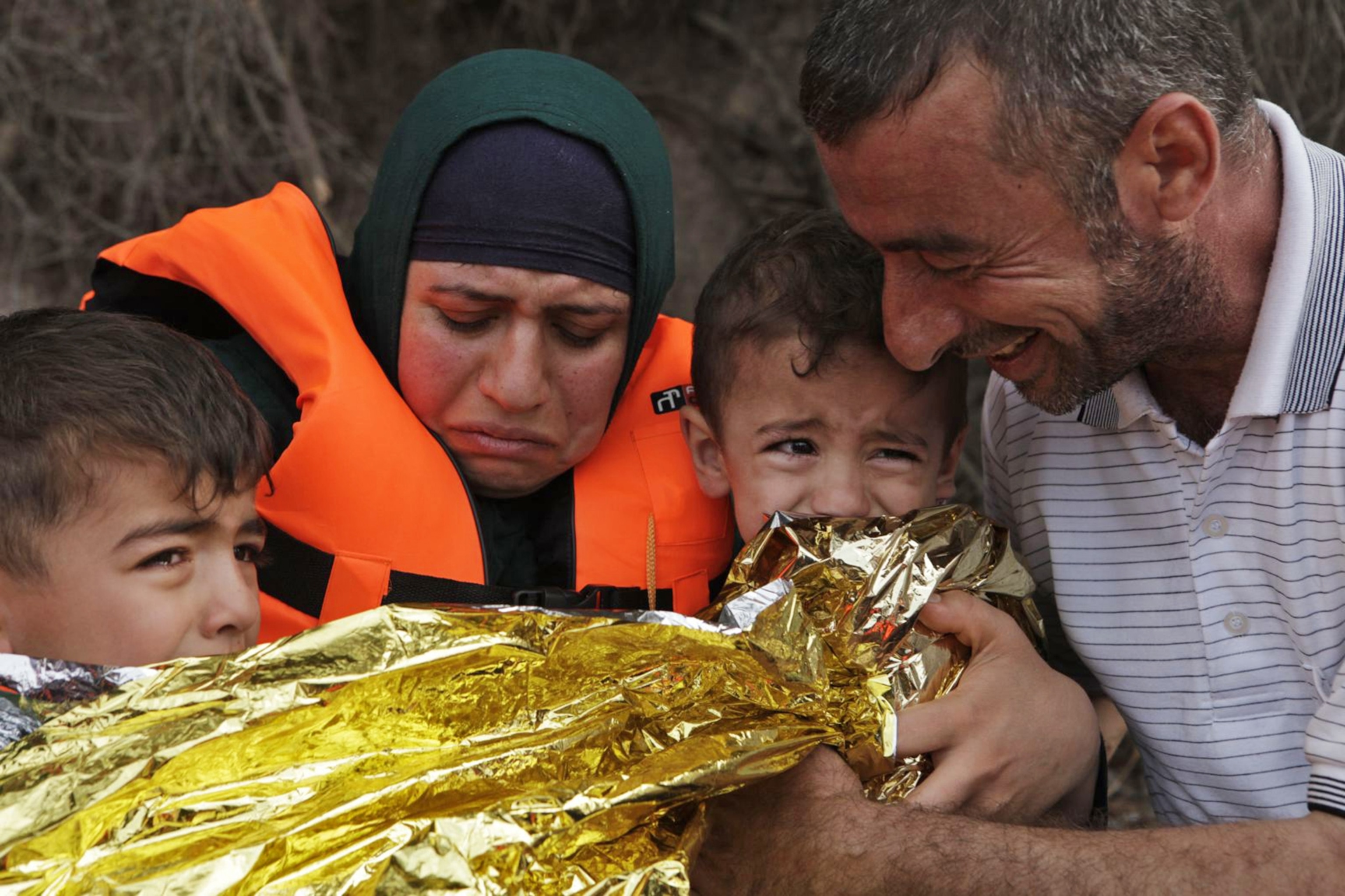 Syrian family having an emotional moment after arriving in Lesvos, Greece from Turkey