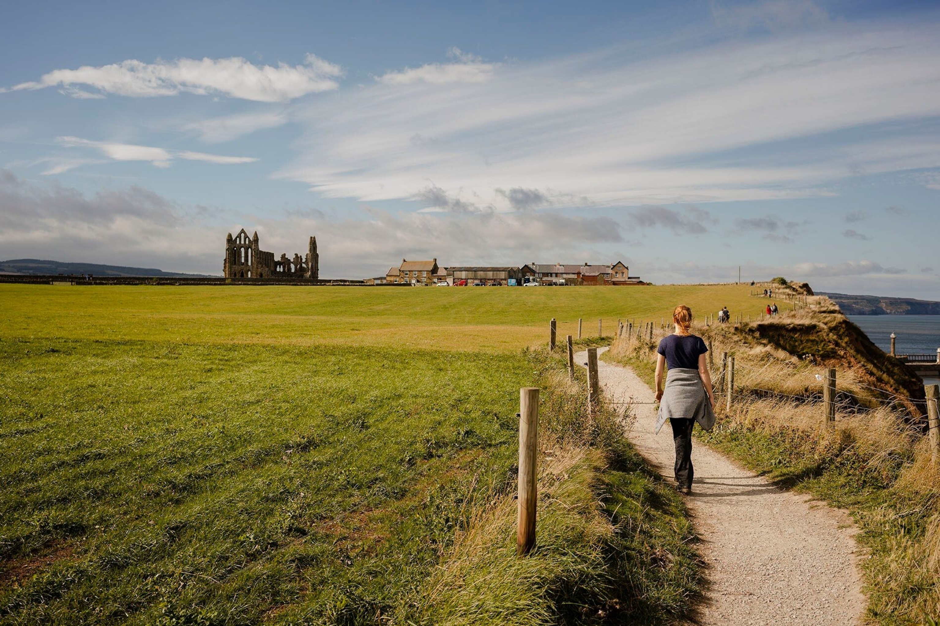 A woman walks along the scenic path between Whitby and Robinshood Bay