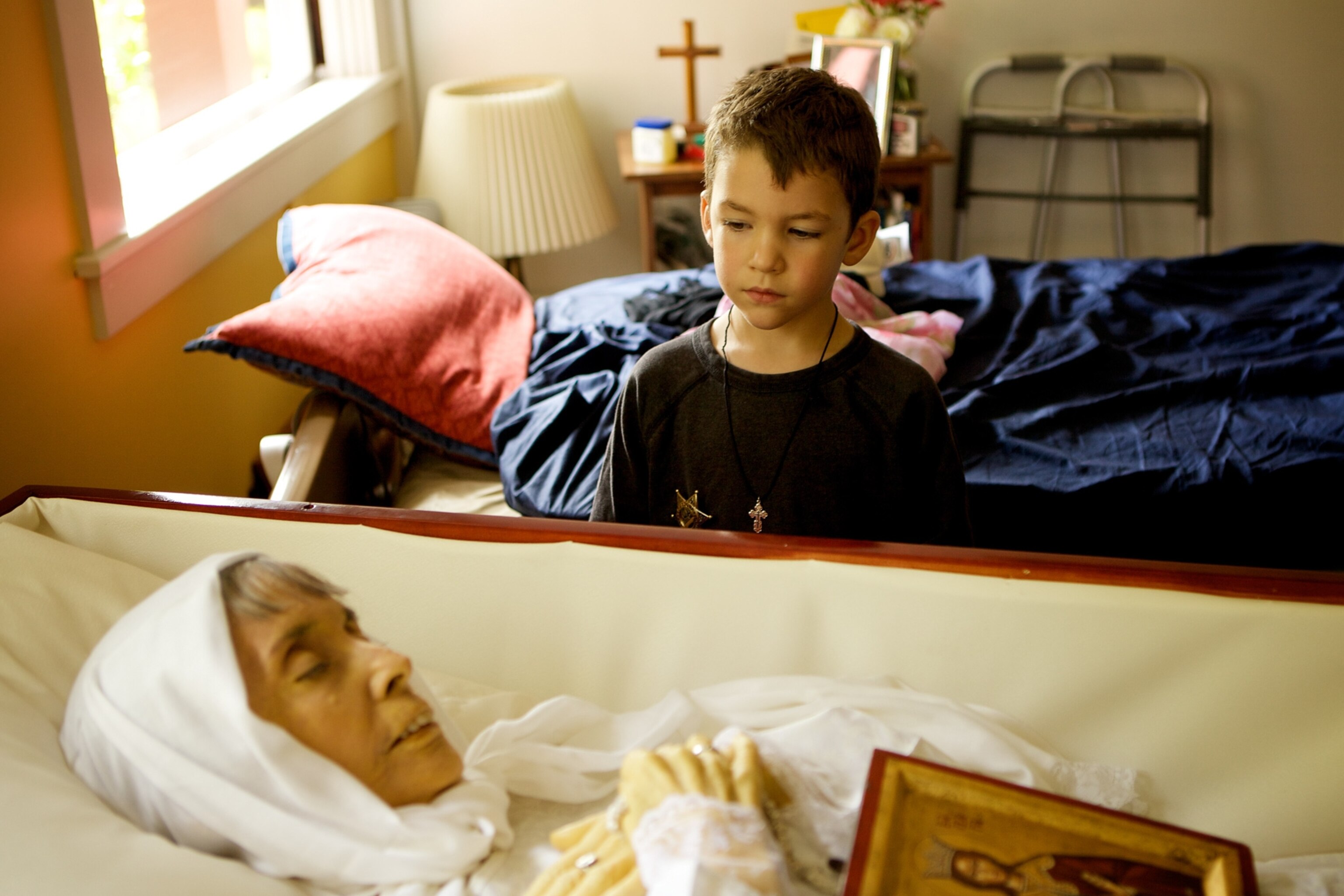 a boy looking at his grandmother in a coffin