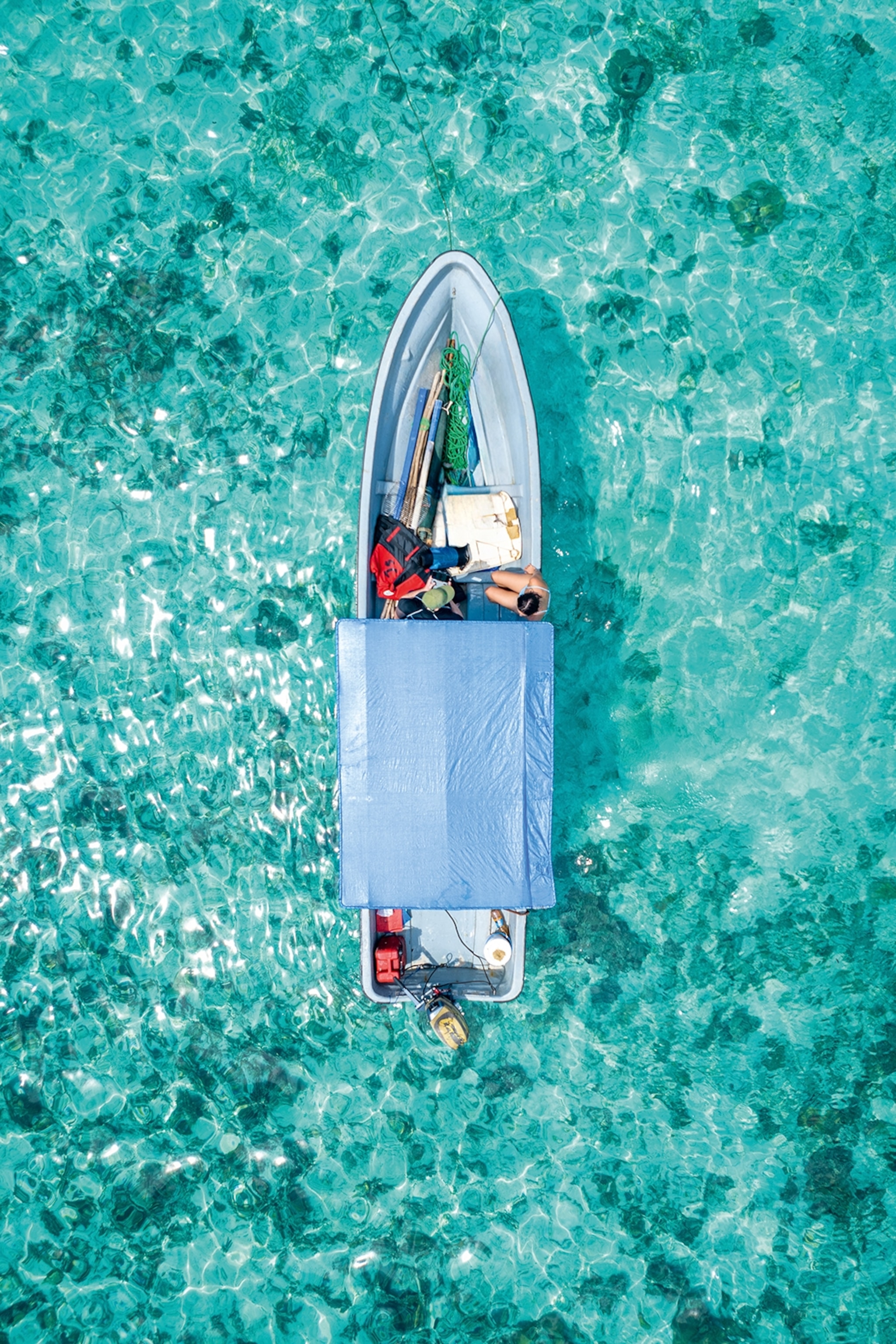 A birds-eye shot of a fishing boat in the clear and glittering waters off the coast of Zanzibar.