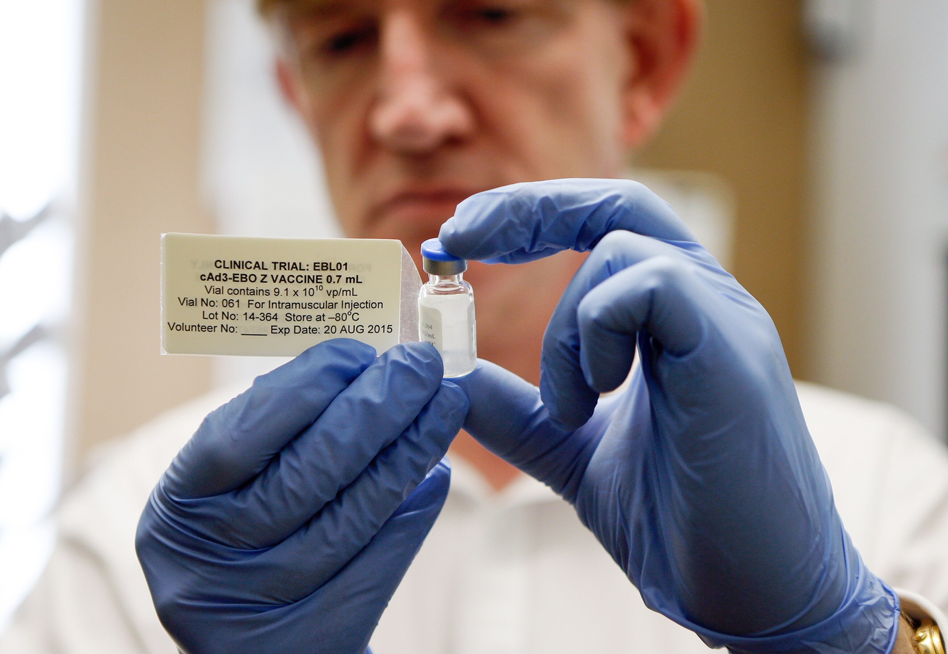 a professor holding a vial of experimental Ebola vaccine.