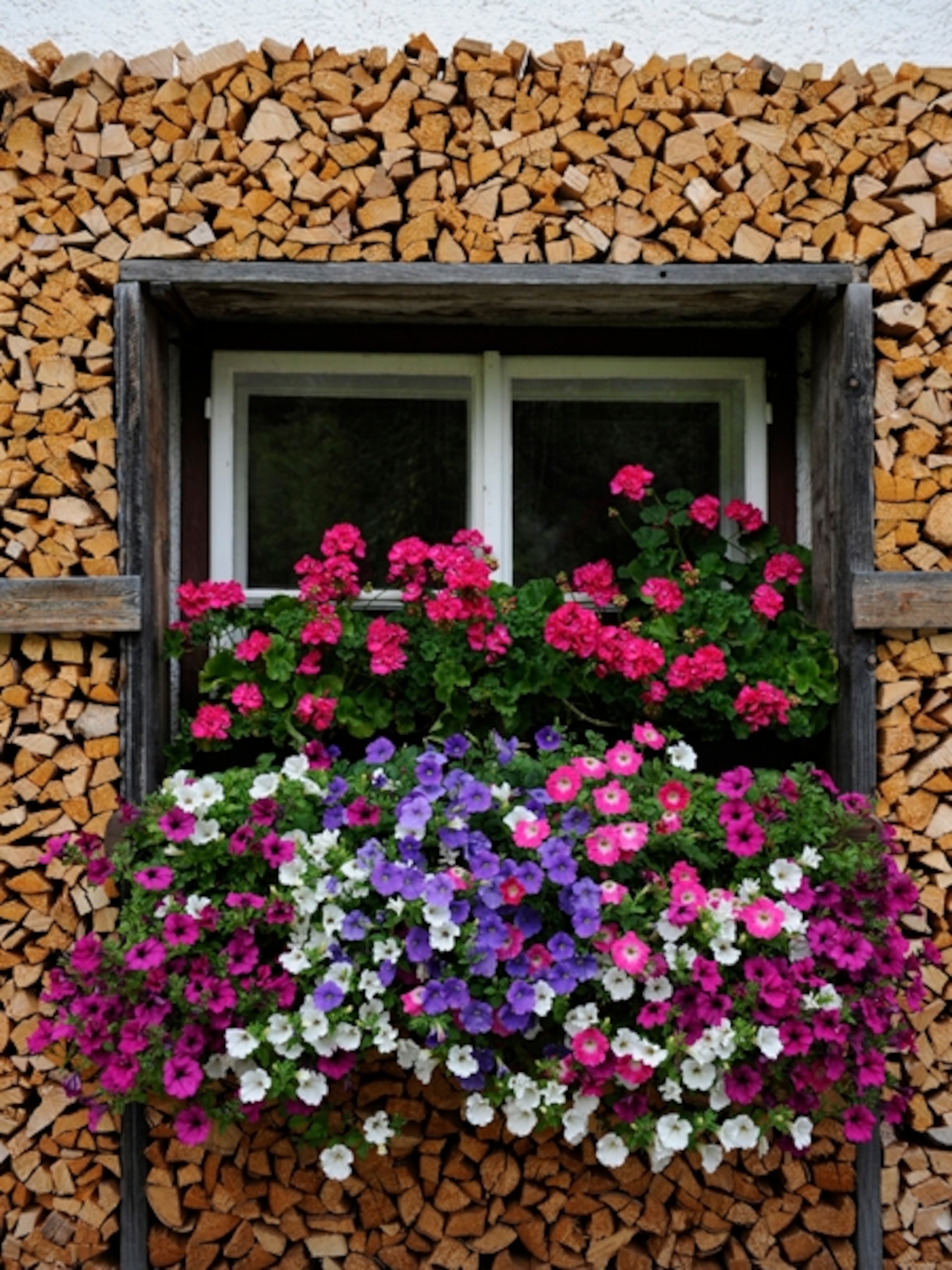 flowers and firewood around a windowsill at Bad Goisern