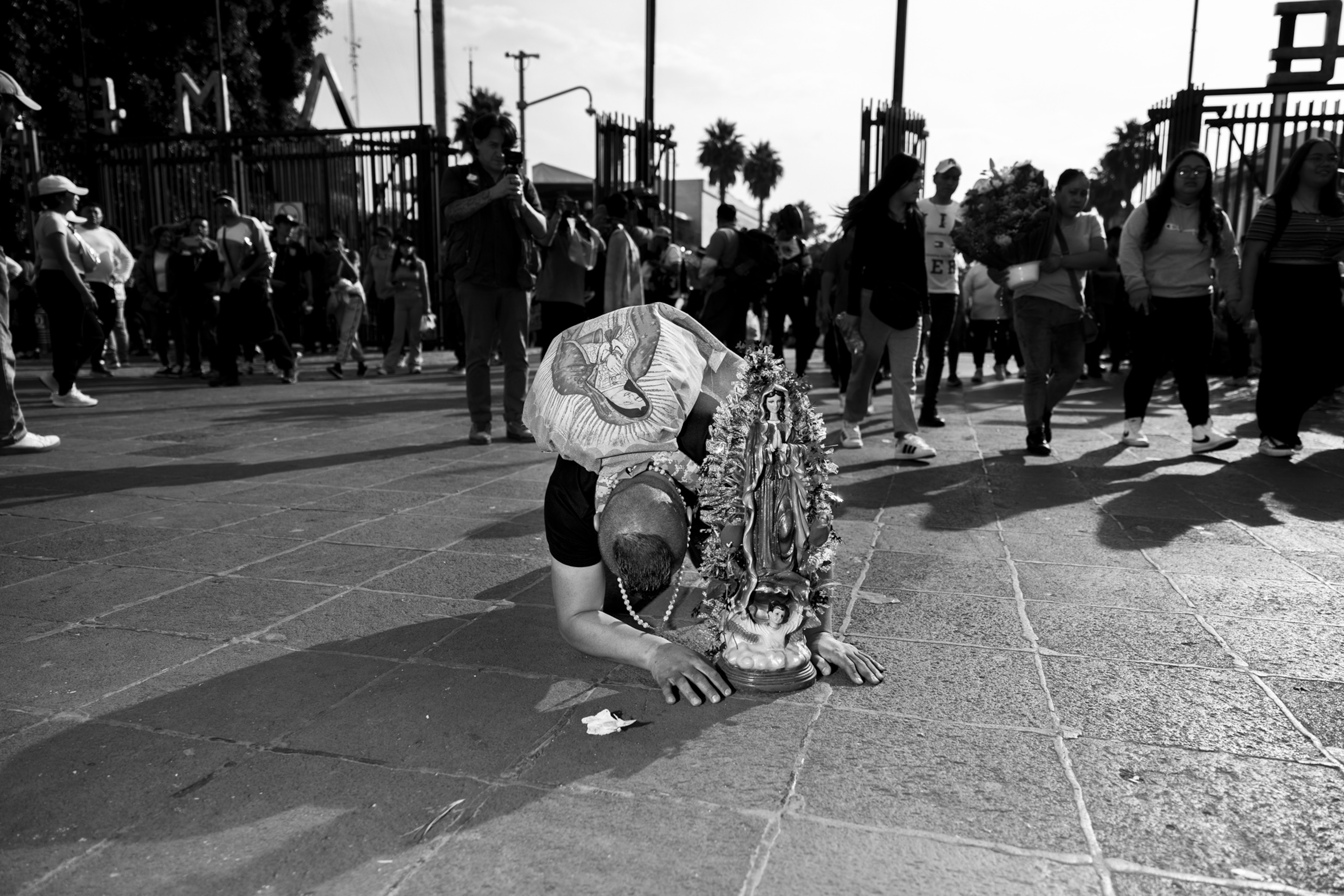 A person bending down to look at a statue.