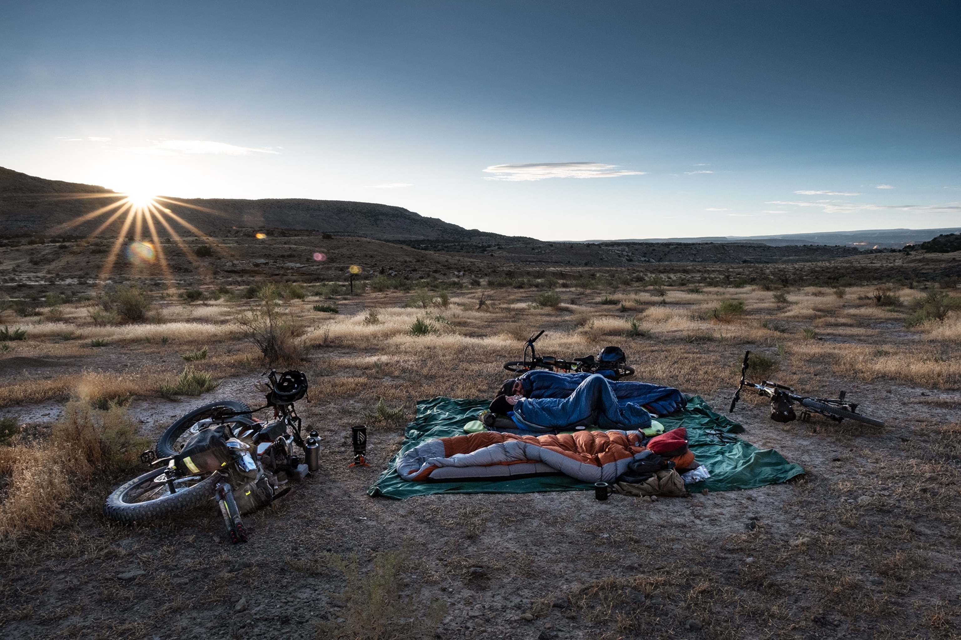 two bikers camping under the open sky on the kokopelli trail in Utah