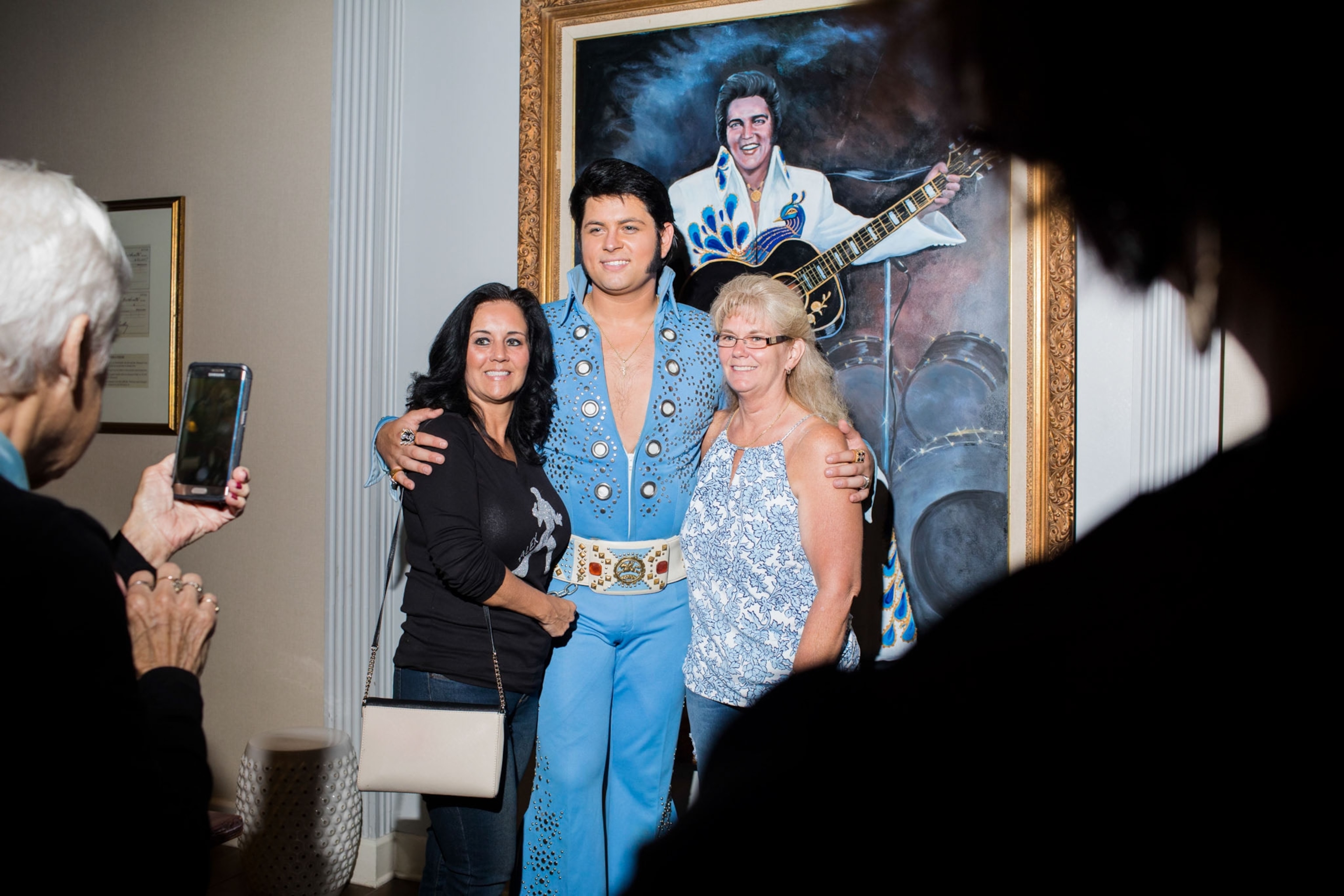 an Elvis tribute artist posing for a picture with fans