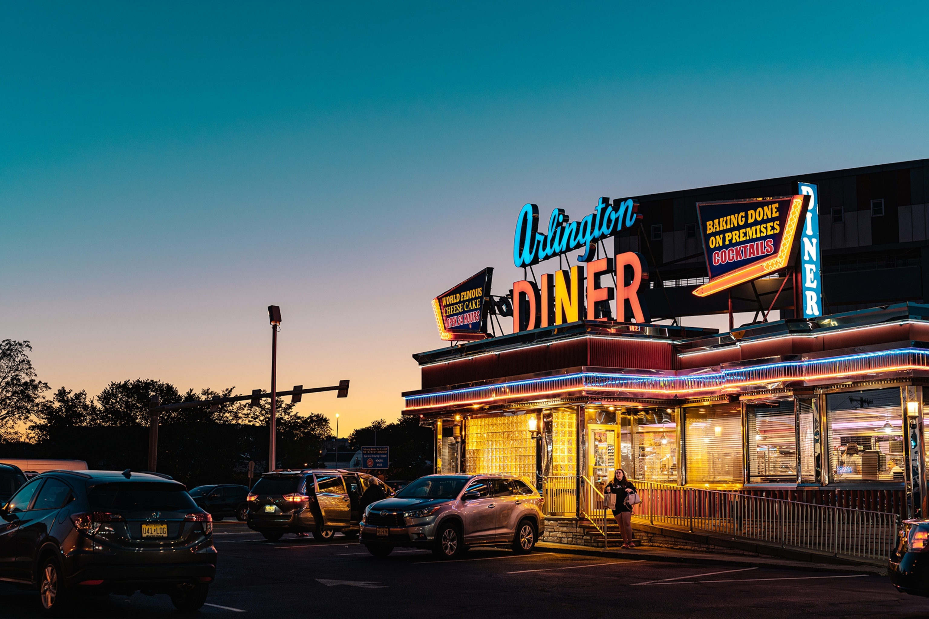 A classic diner with neon lettering on the roof at late sunset.
