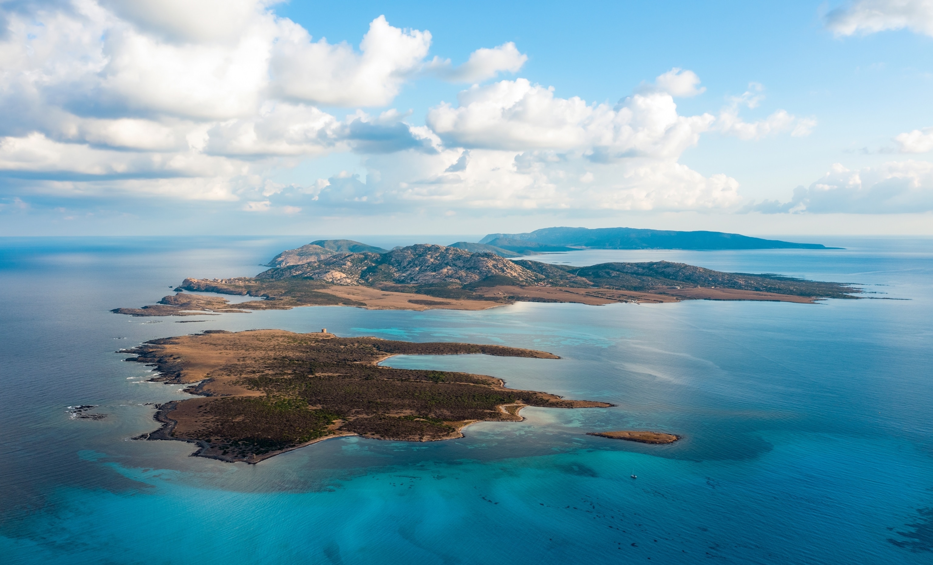 An aerial view of an island surrounded by blue water