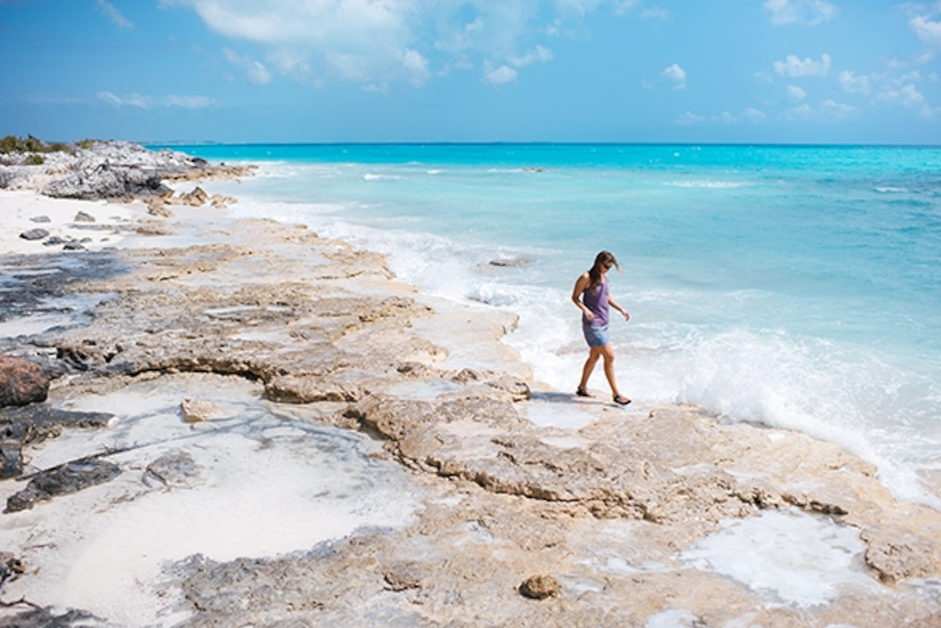 Adventurer/filmmaker Tharia Sheather walks the rocky shores of paradise on Long Island; Photograph by Max Lowe