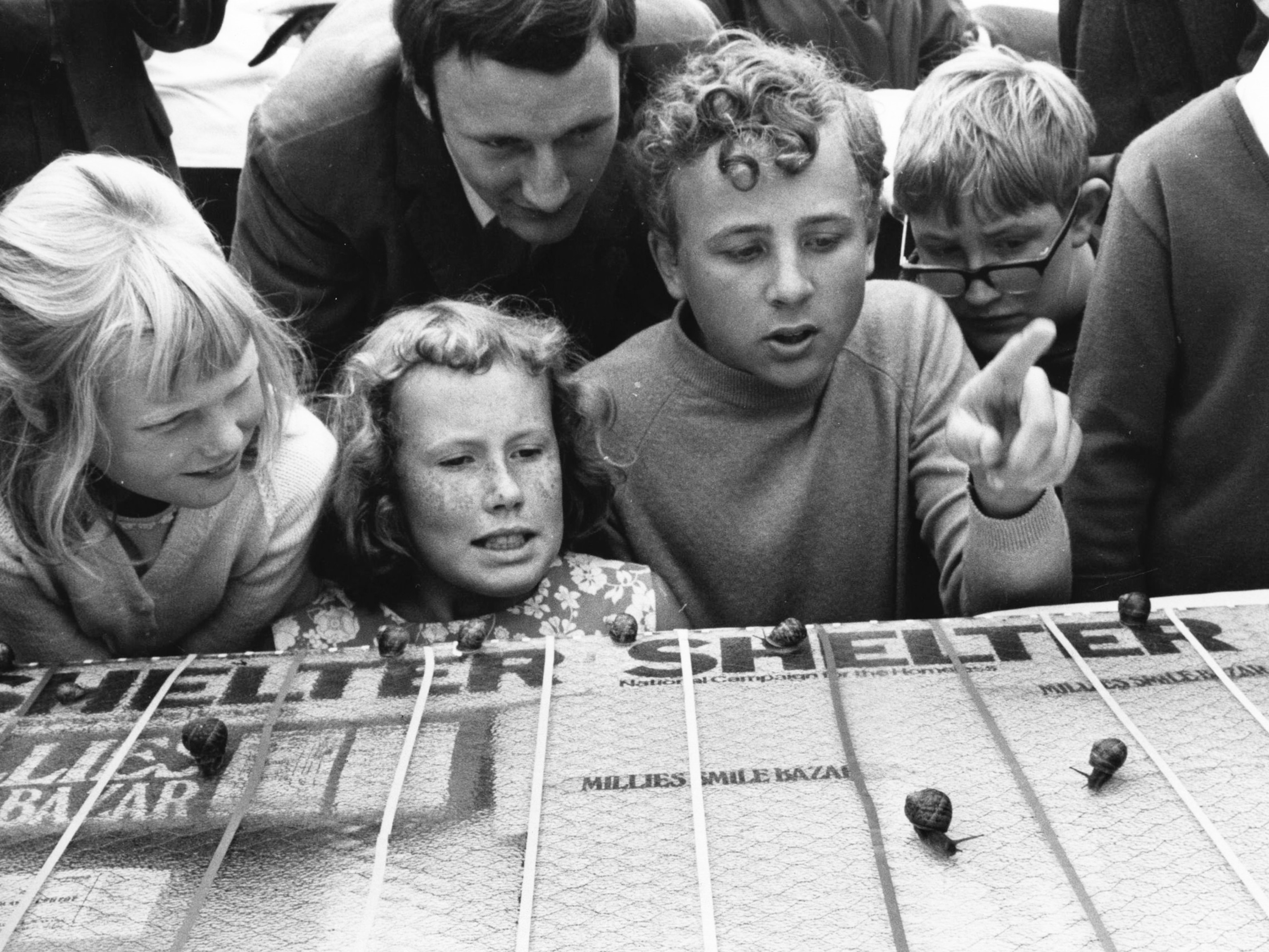 Children watch as snails race in Brighton, United Kingdom.