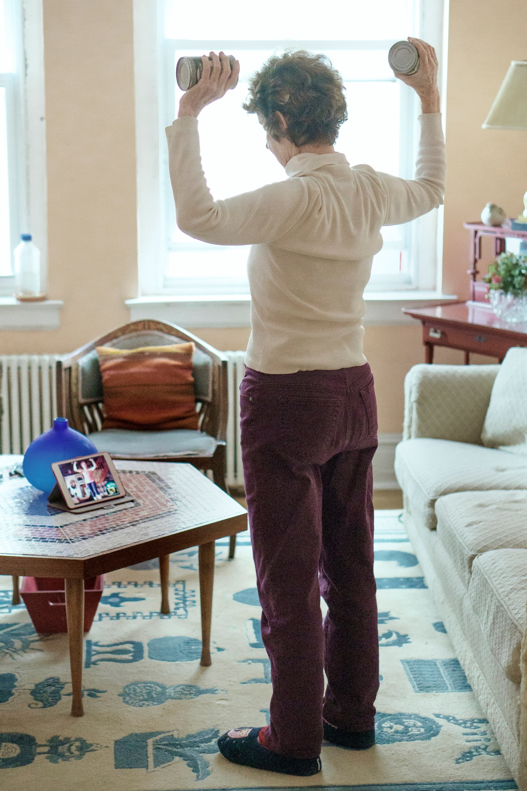 a woman lifting small weights in her apartment in New York City