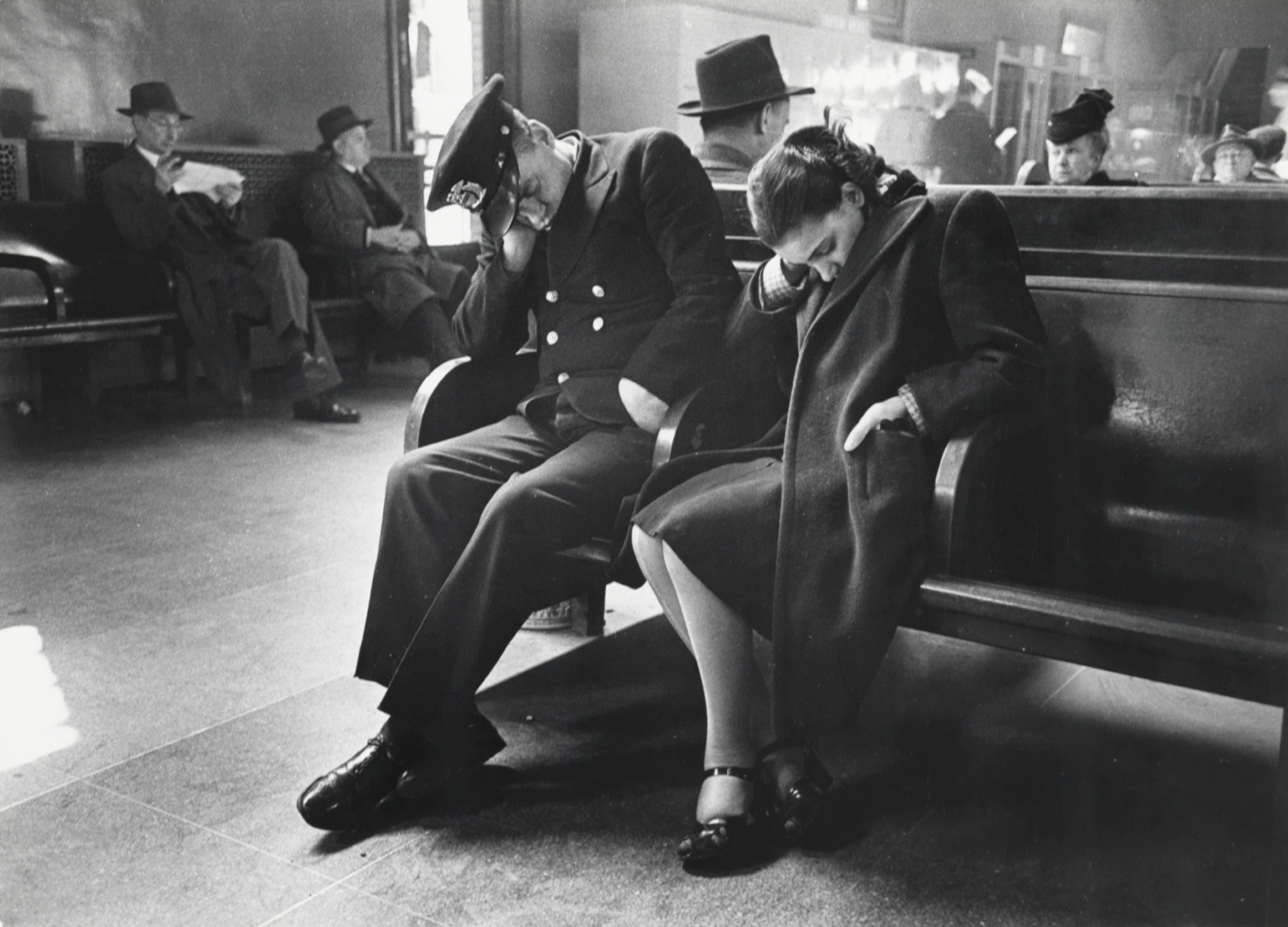 travelers resting on the benches in a New York bus terminal