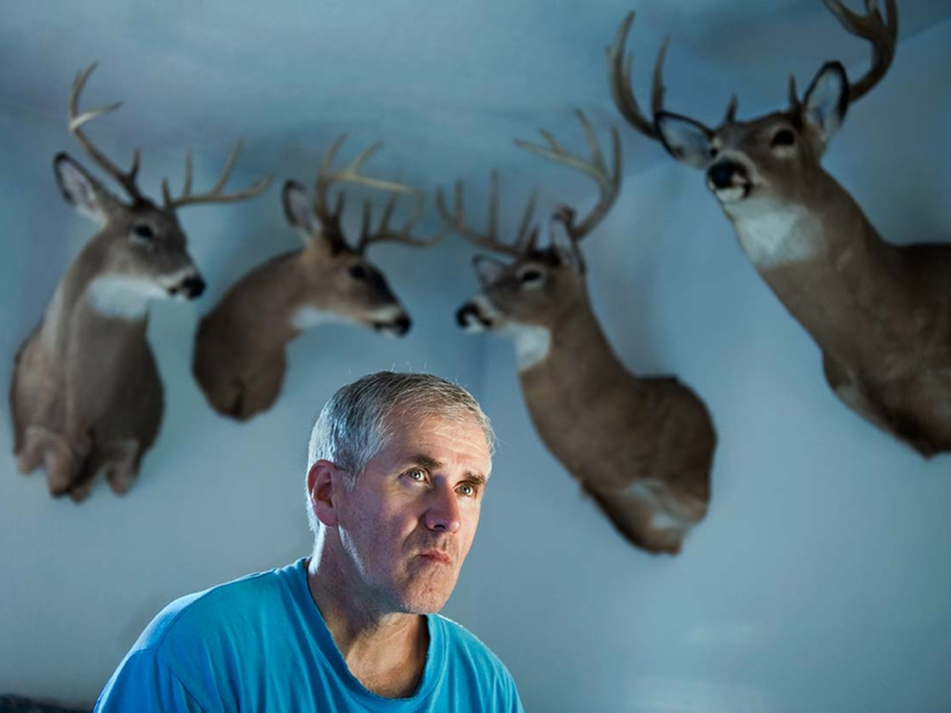Landowner Ron Gulla beneath mounted heads of deer.