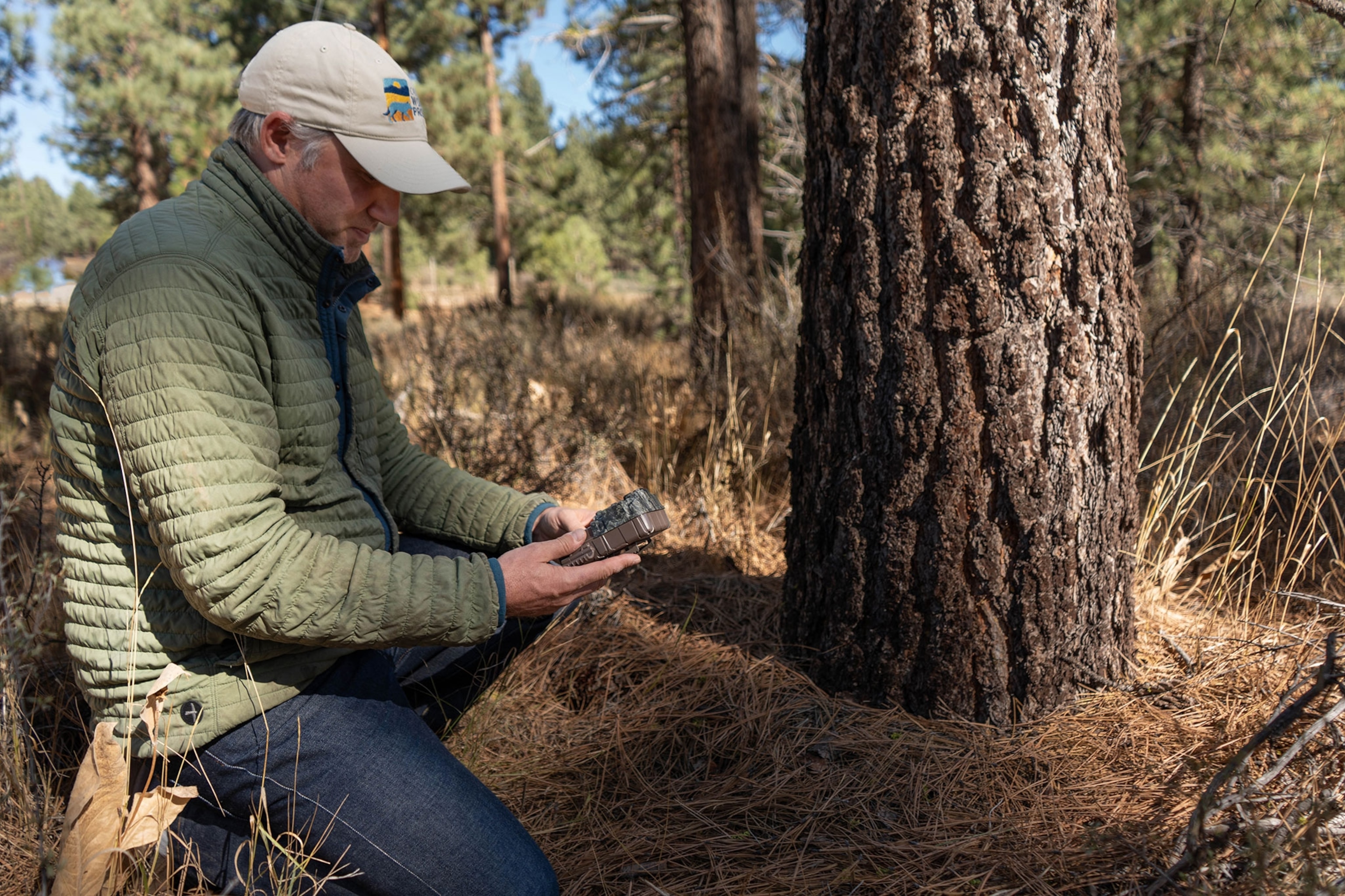 A man looks down at a device in his hand.