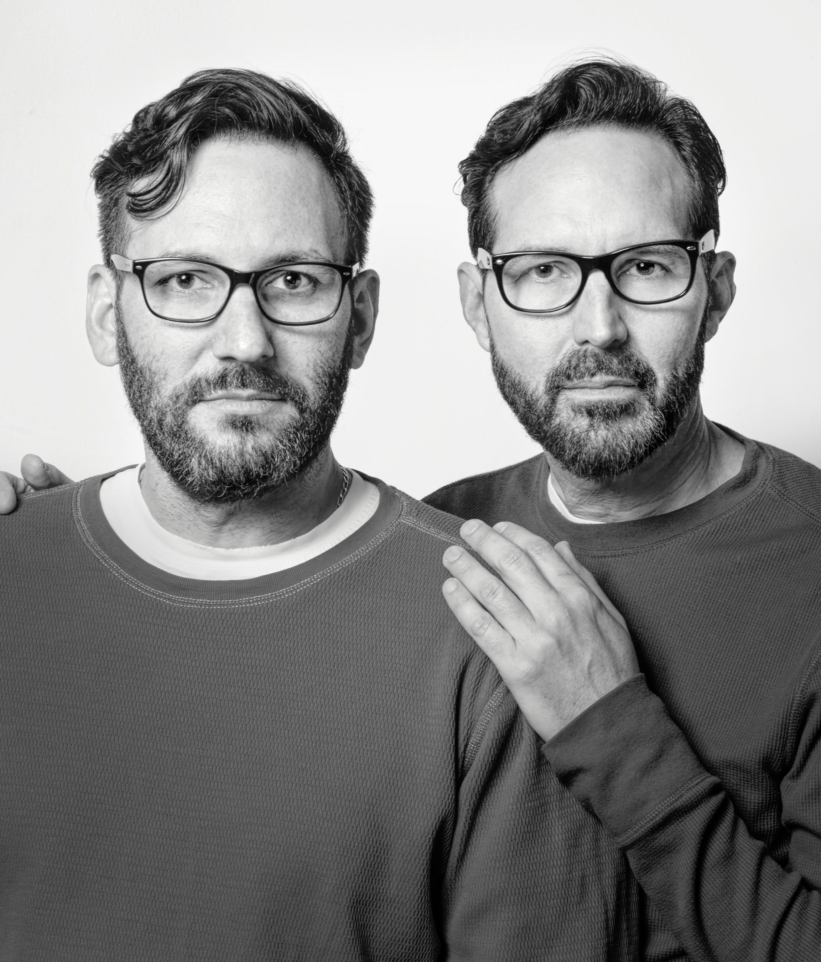 Head-and-shoulders portrait of two middle-aged white men with glasseswho resemble each other closely