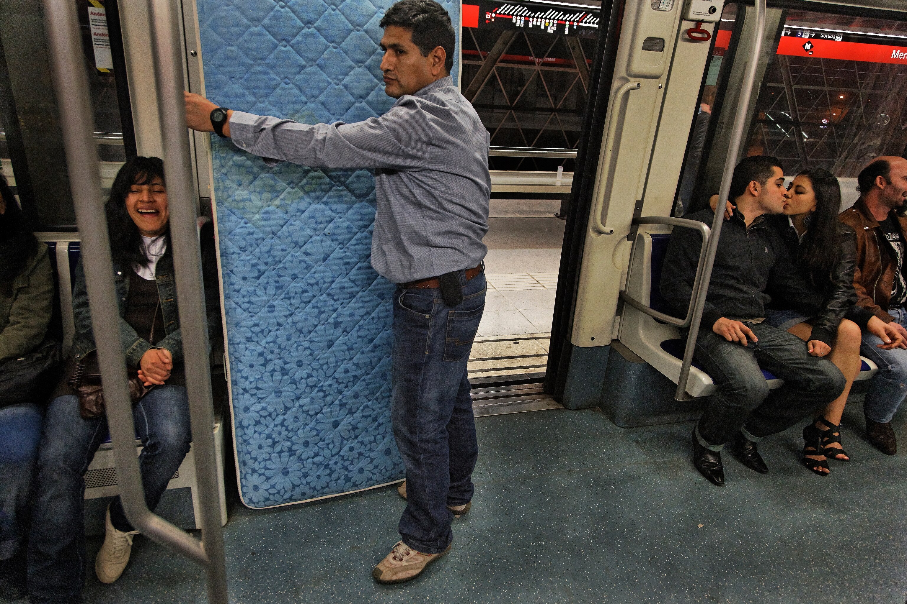 A man transports a mattress on the Barcelona metro.