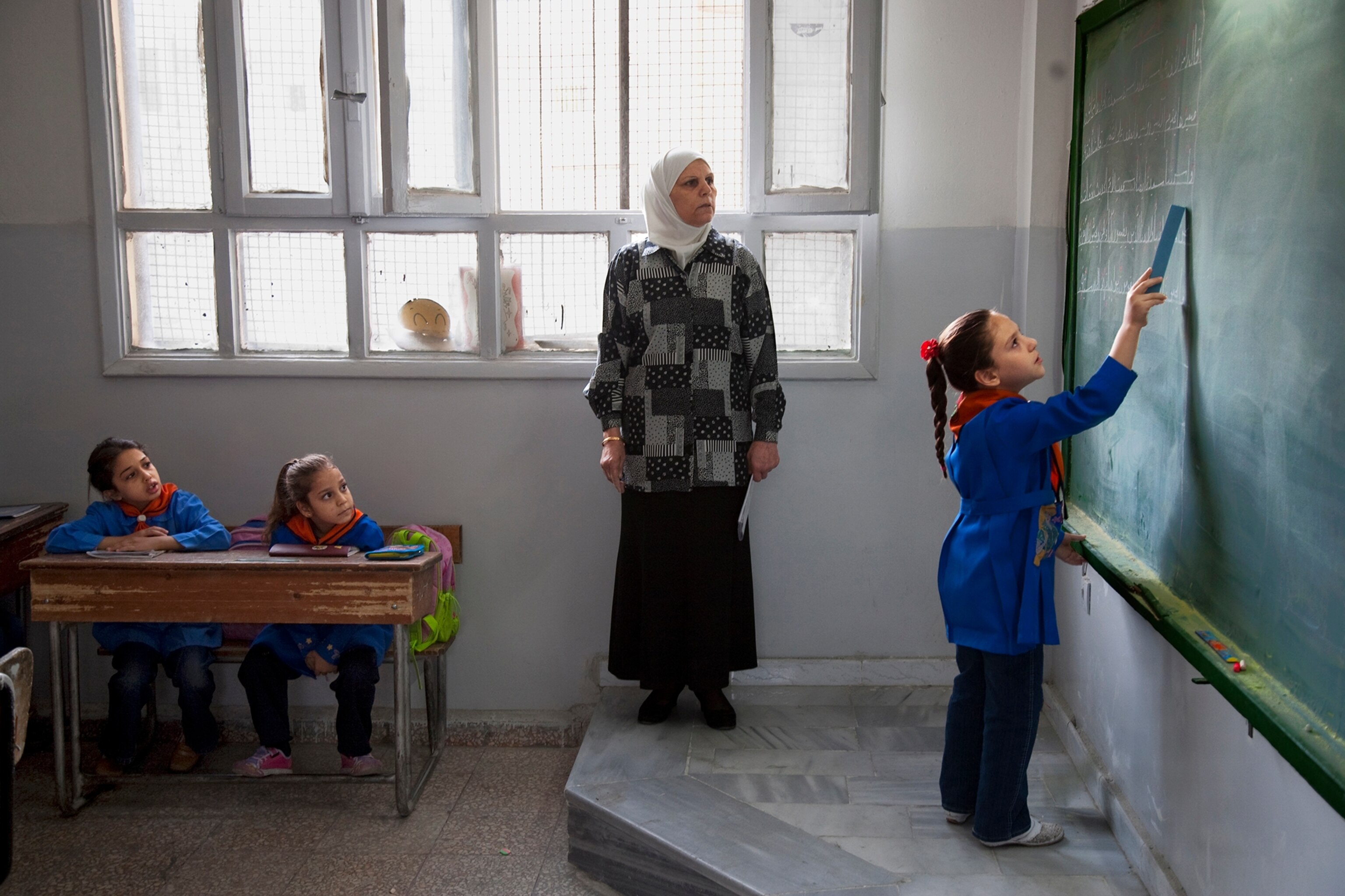 Iraqi refugees learn with Syrian children at a public school.