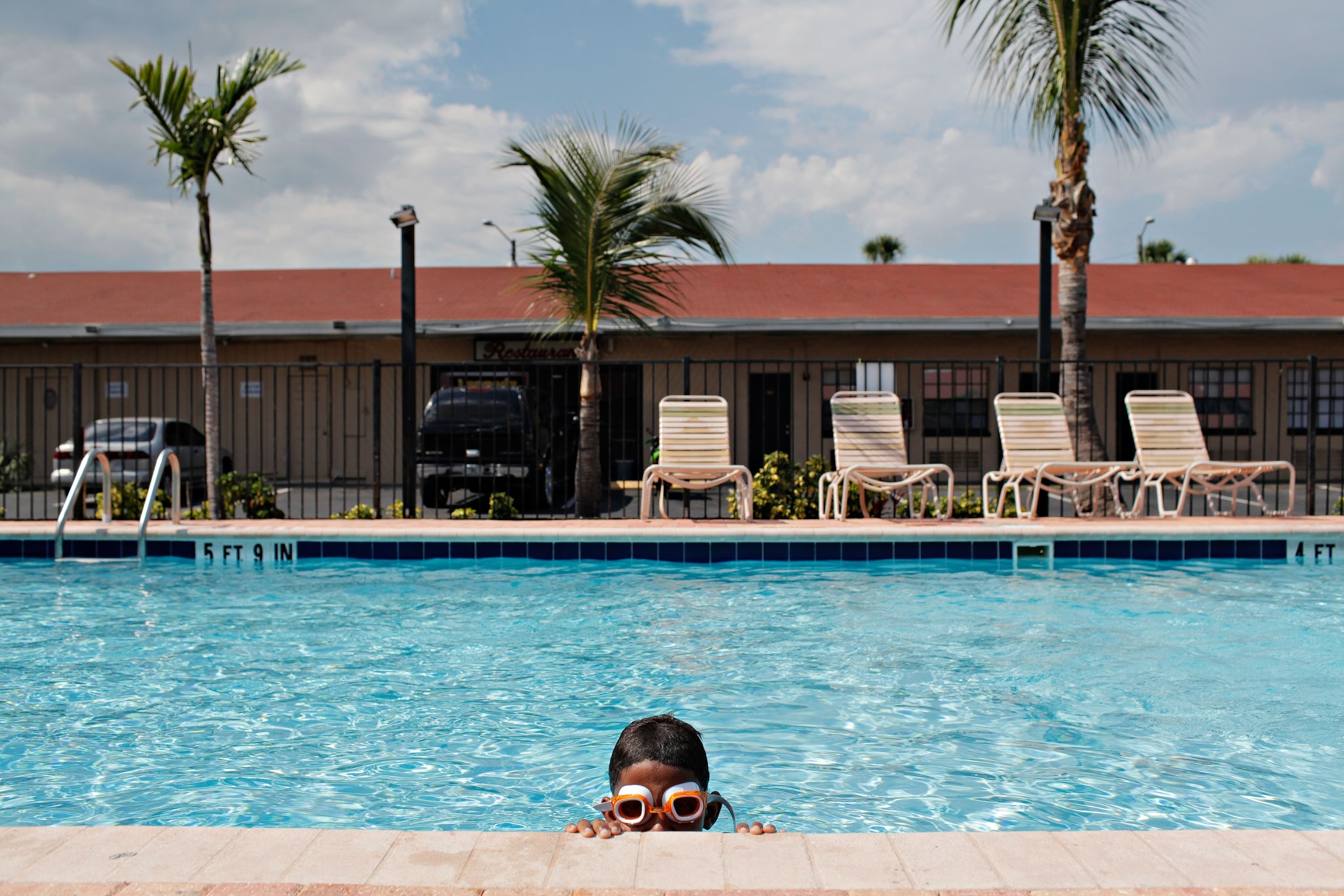 boy in goggles pool side
