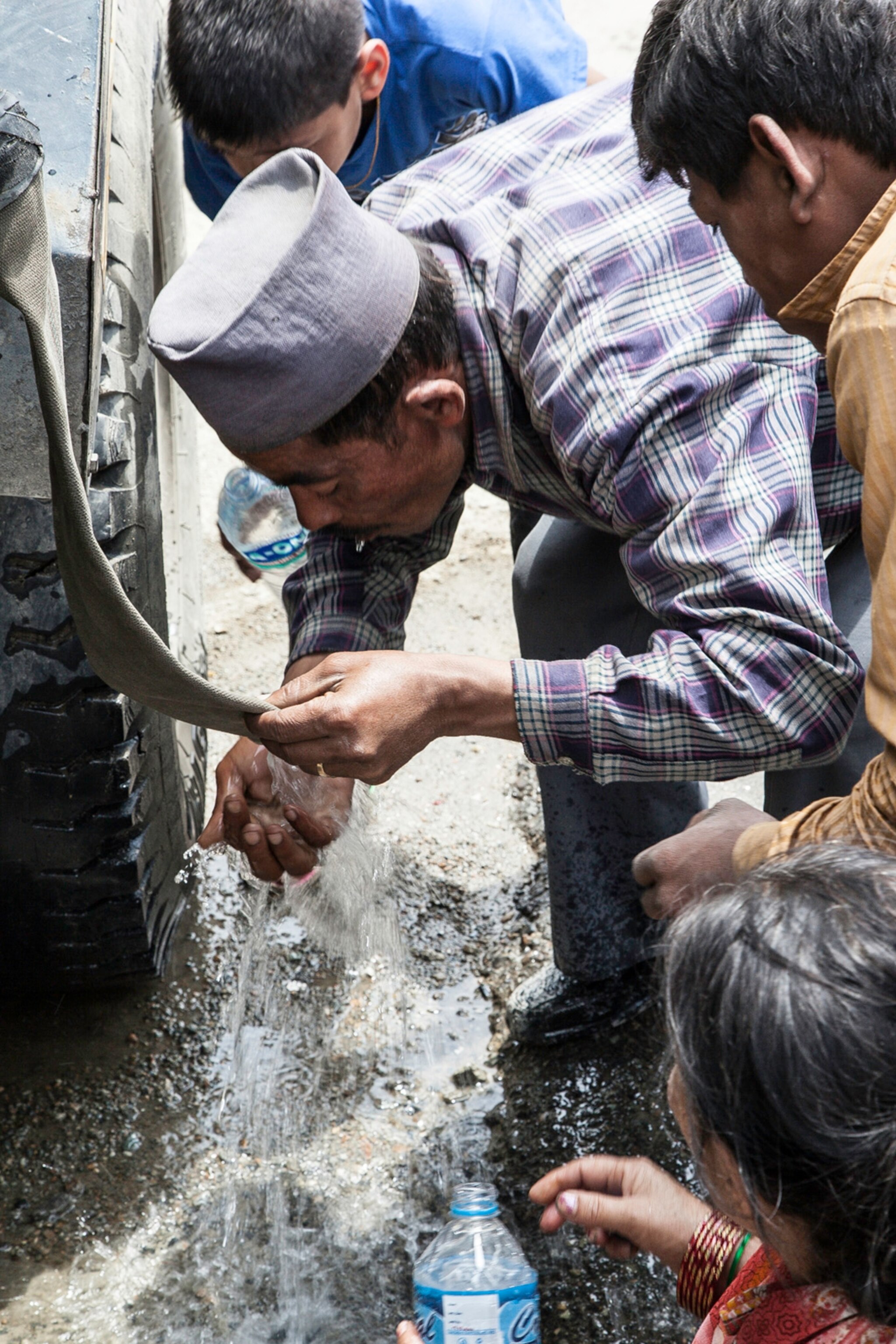 Nepalese finding brief respite from thirst taken from government supplied water truck