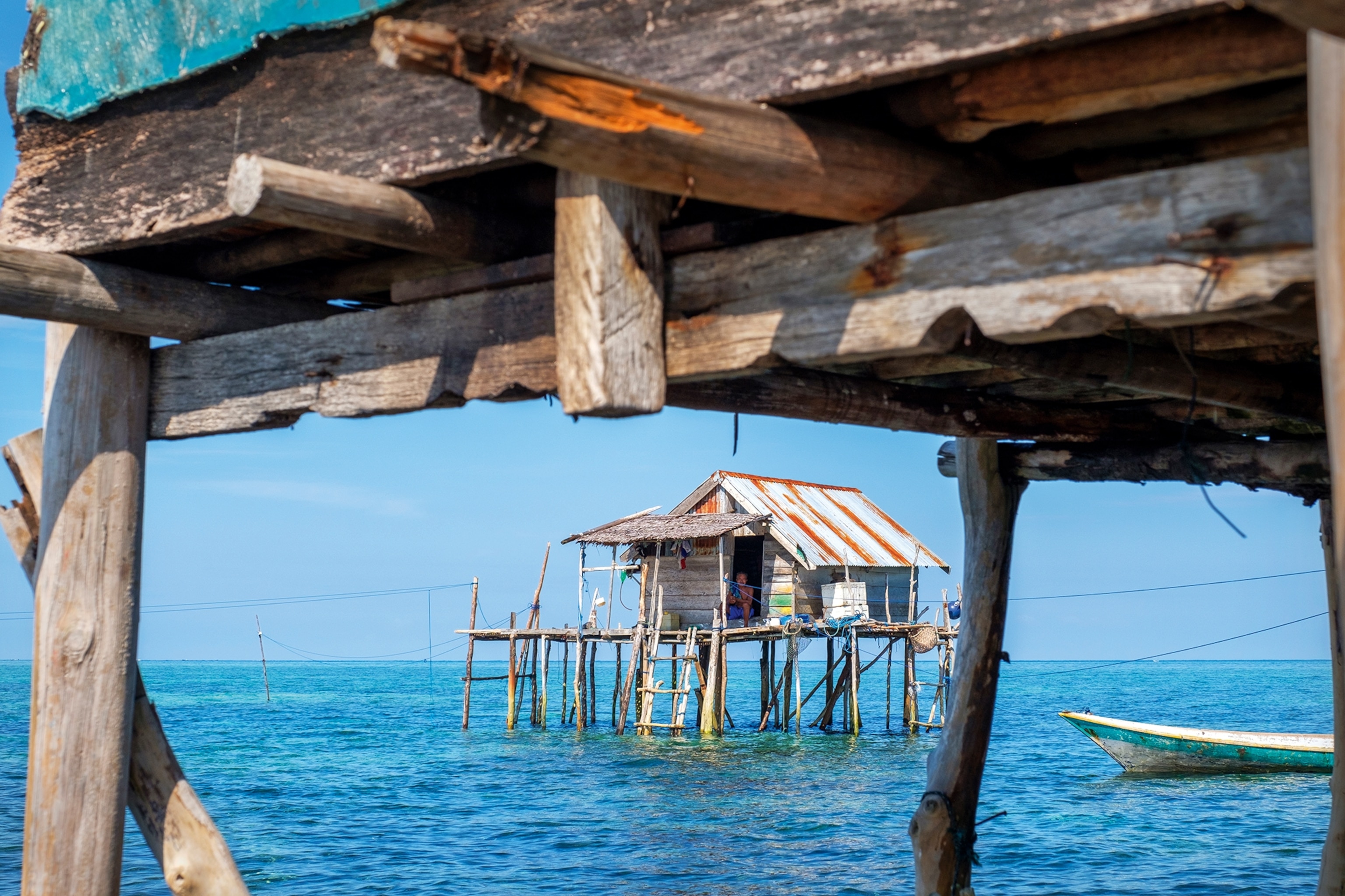 A simple wooden house built on stilts in the ocean.