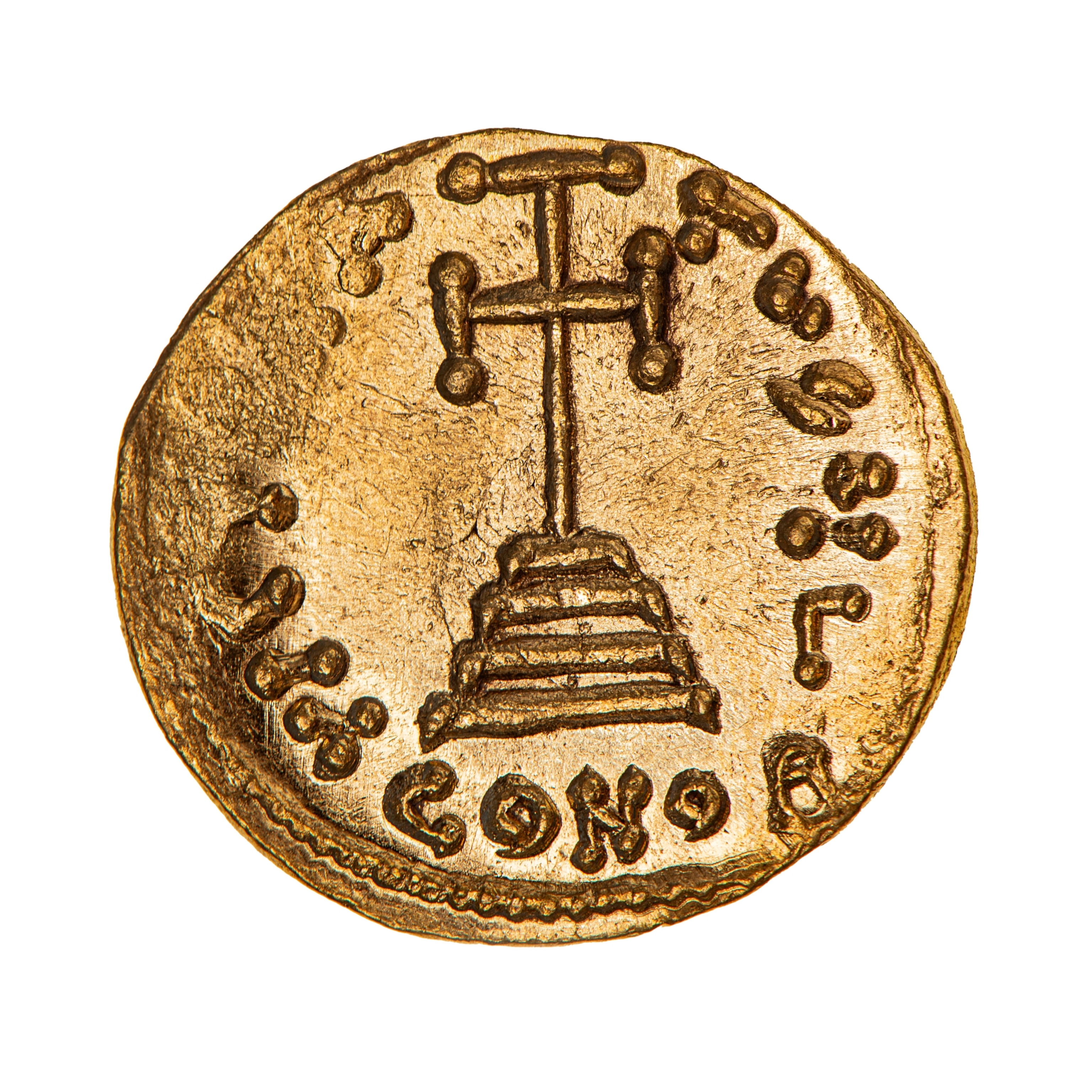 A round, gold coin with a stamped image of various symbols.
