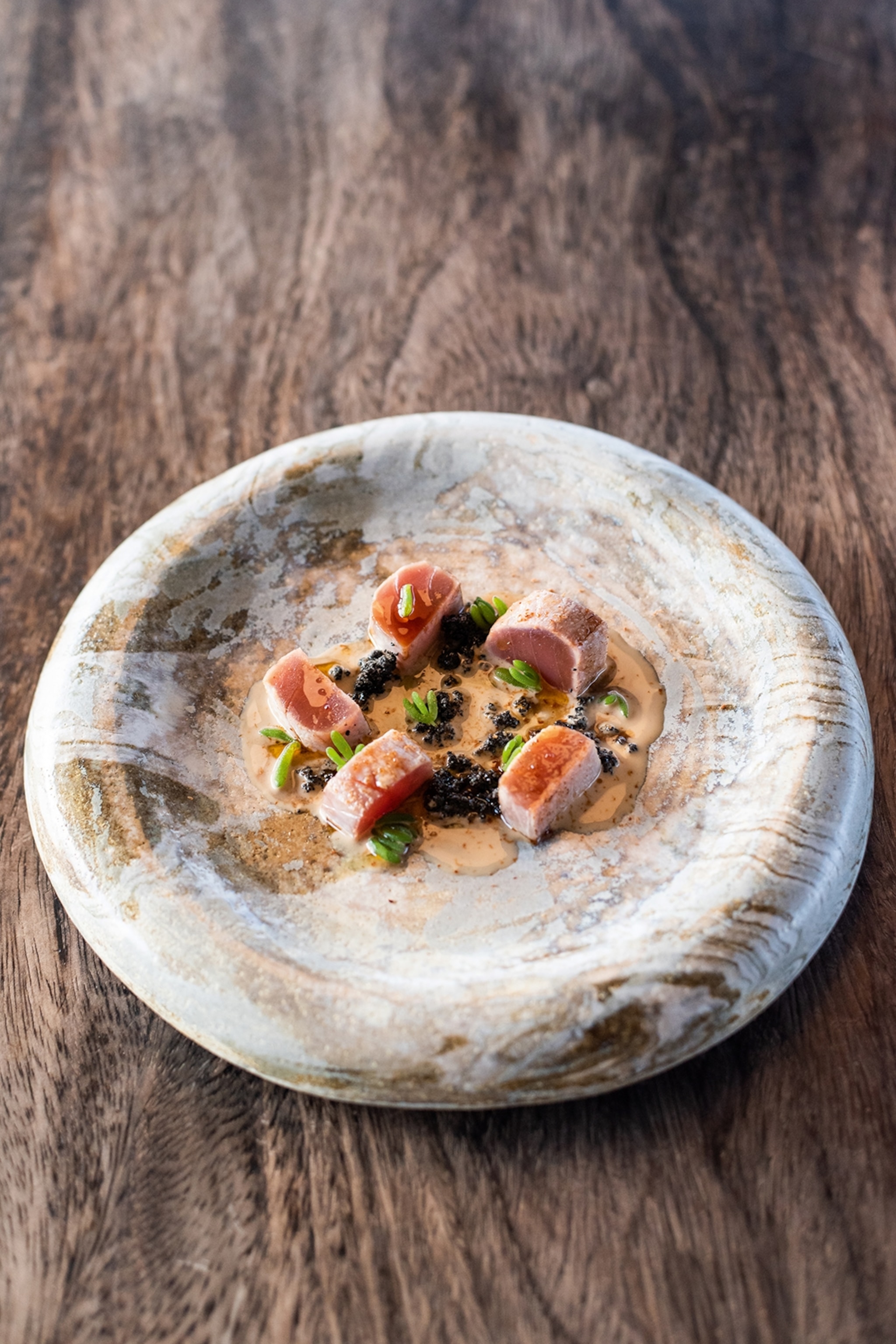 A plate of neatly presented tuna tataki.