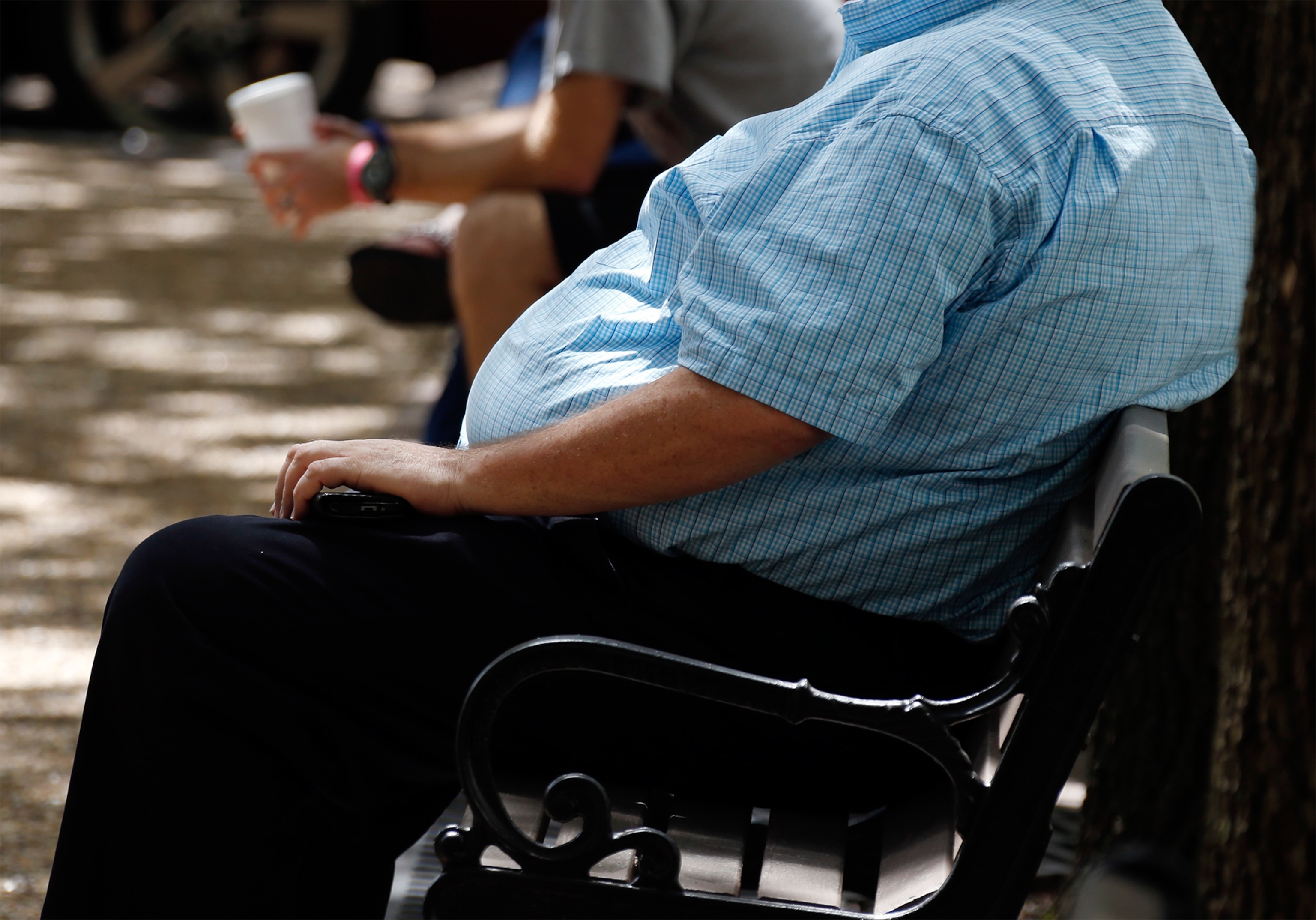 an overweight man sitting on a bench in Mississippi.
