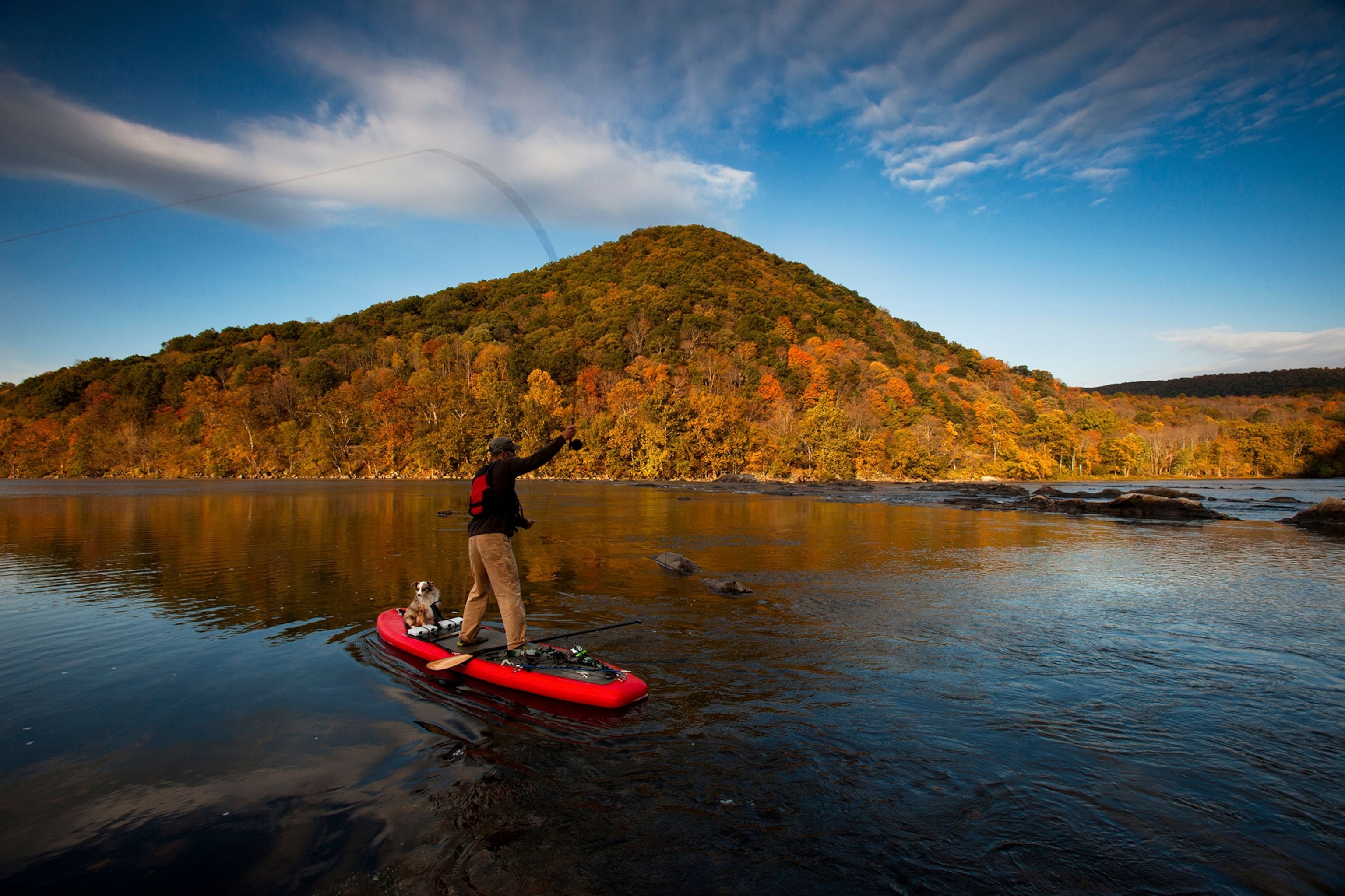a man and his dog on a stand-up paddle board in Virginia