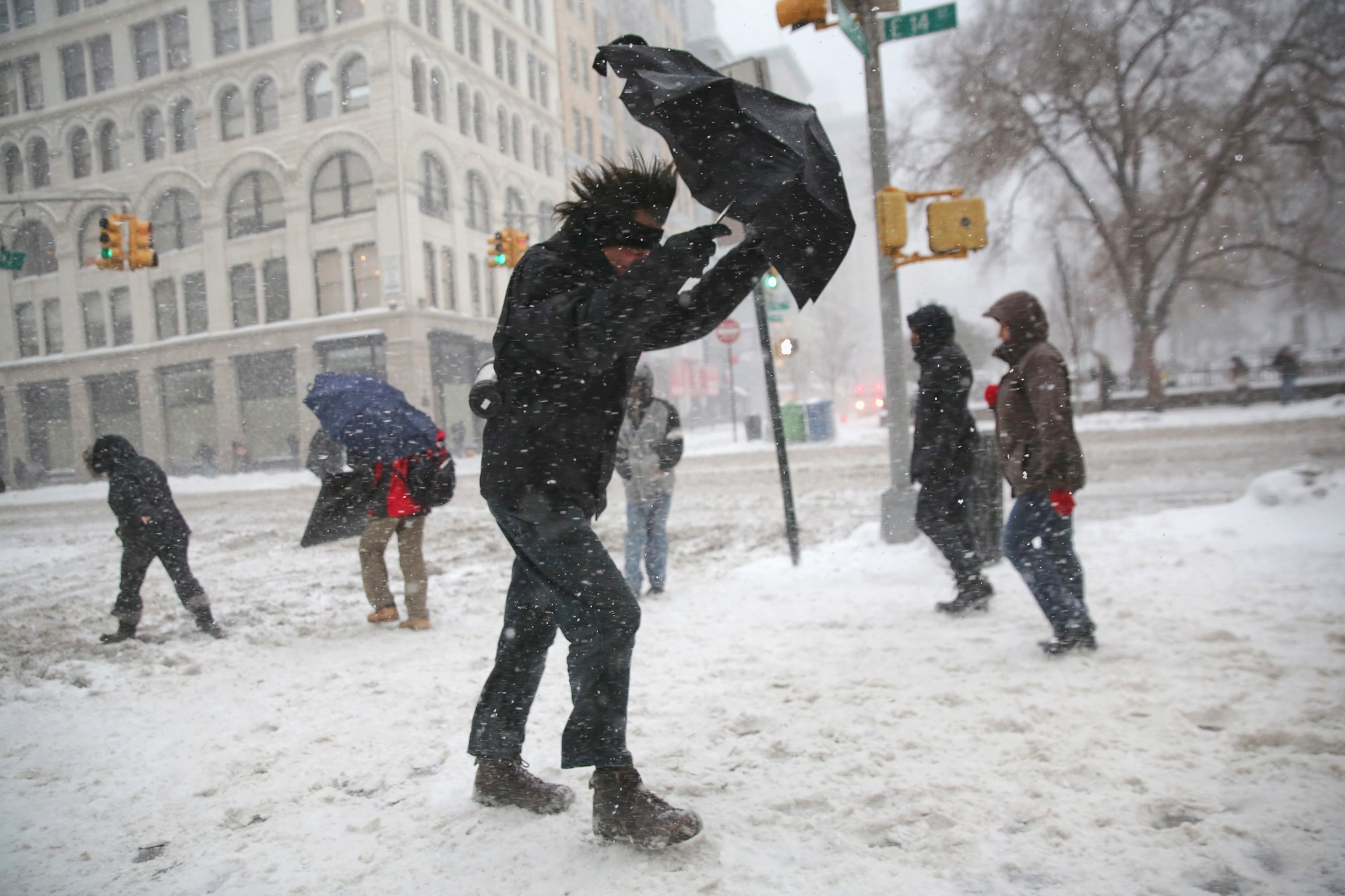 A man braces his umbrella while walking through the snow in NY City.