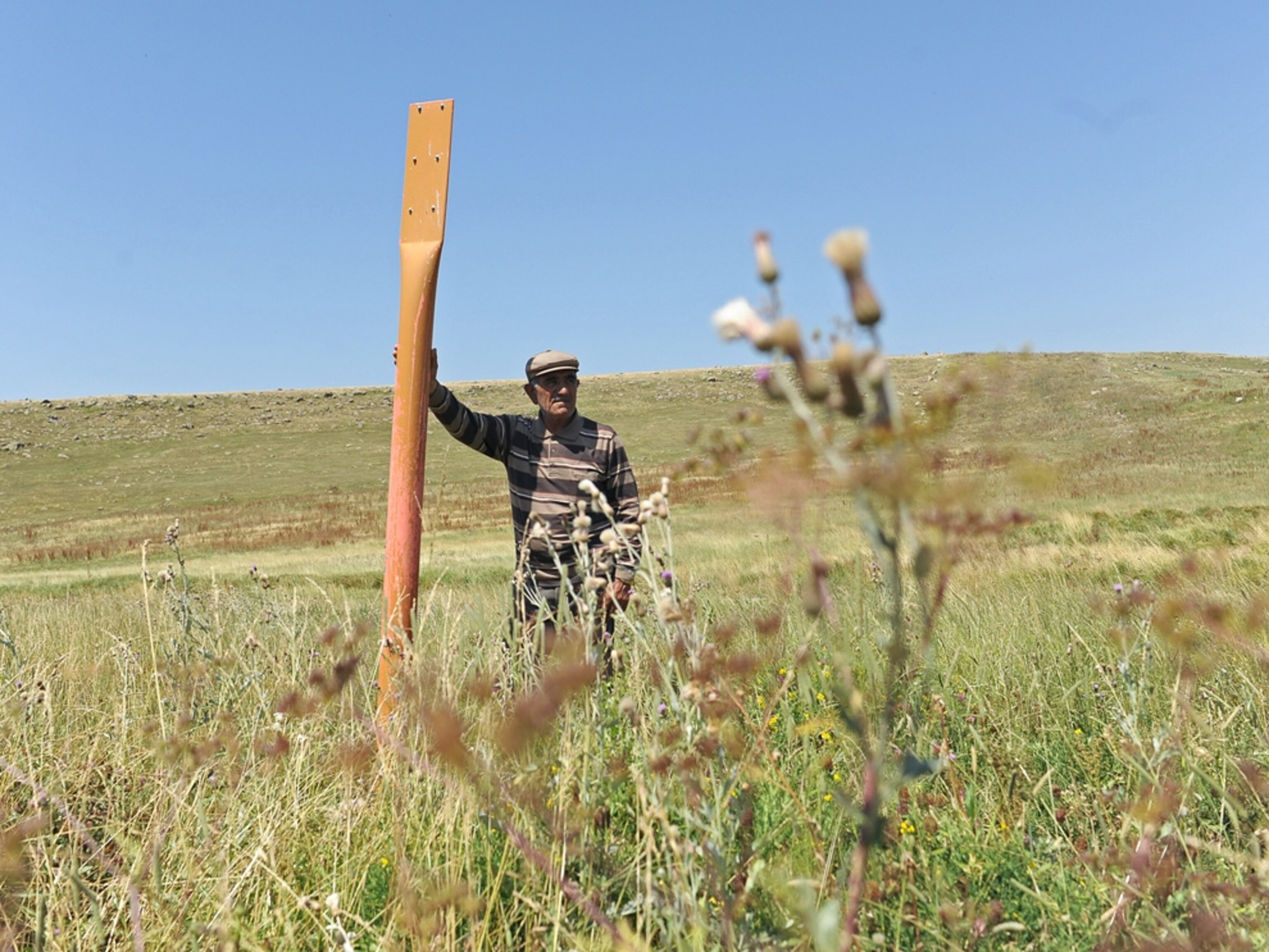 Rifat Yildiz stands beside a marker for the BTC pipeline in Dagci, Turkey