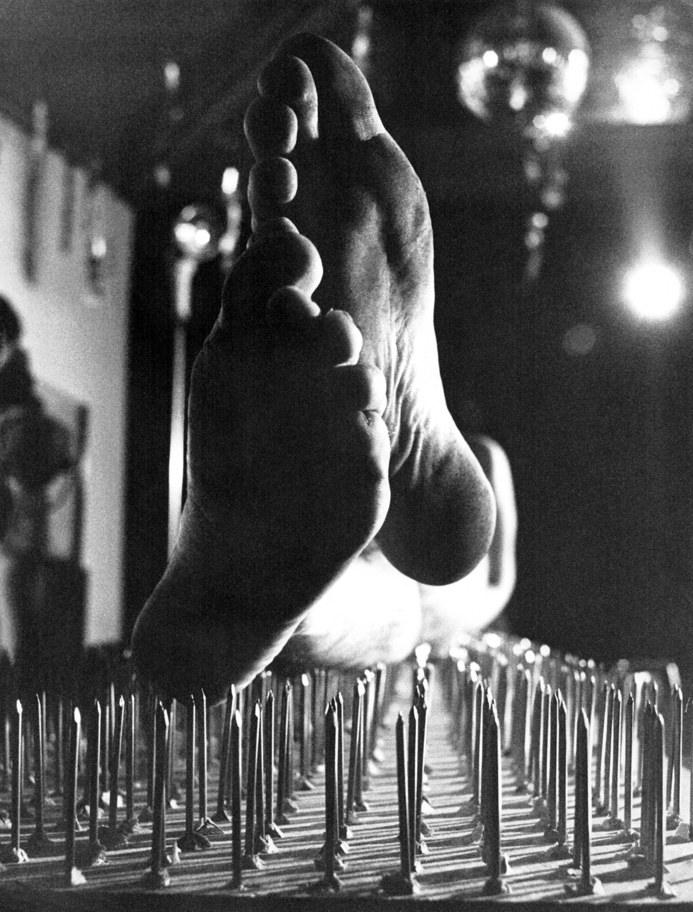 The bottom of someone's feet as they lay atop a bed of nails.