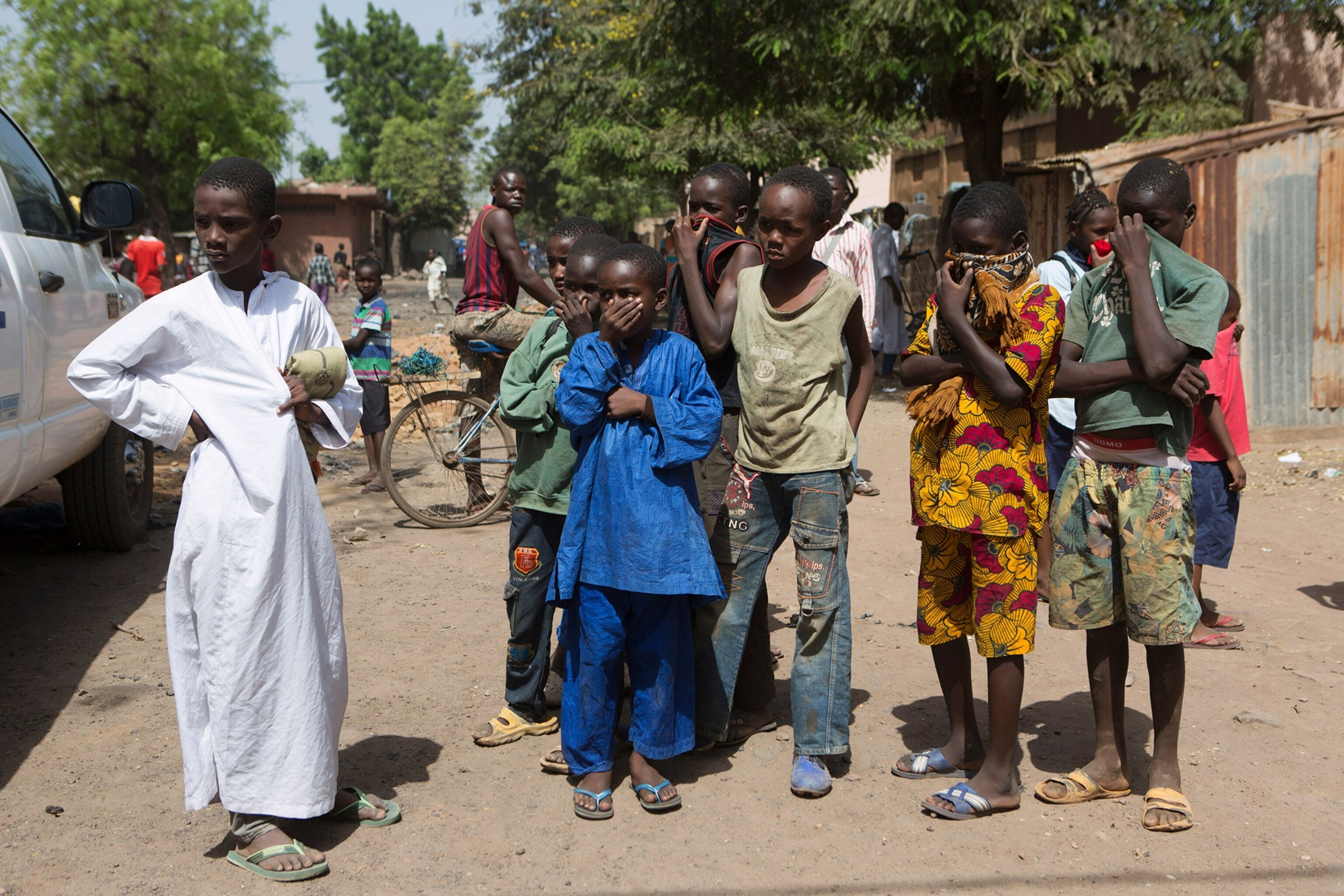 Children watch as health workers spray disinfectants at a mosque in Bamako November 14, 2014.