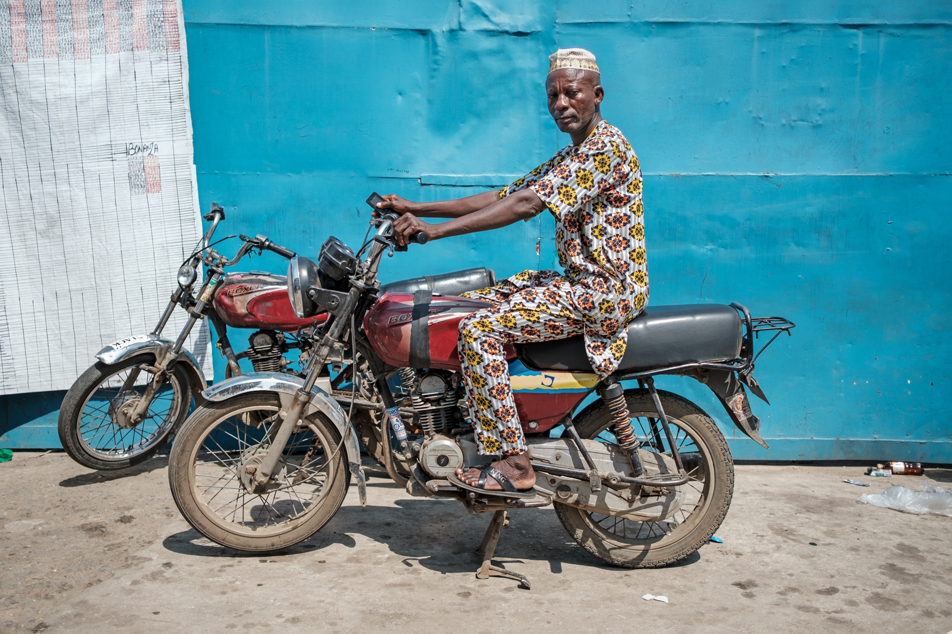 Older man on his red bike next another bike.