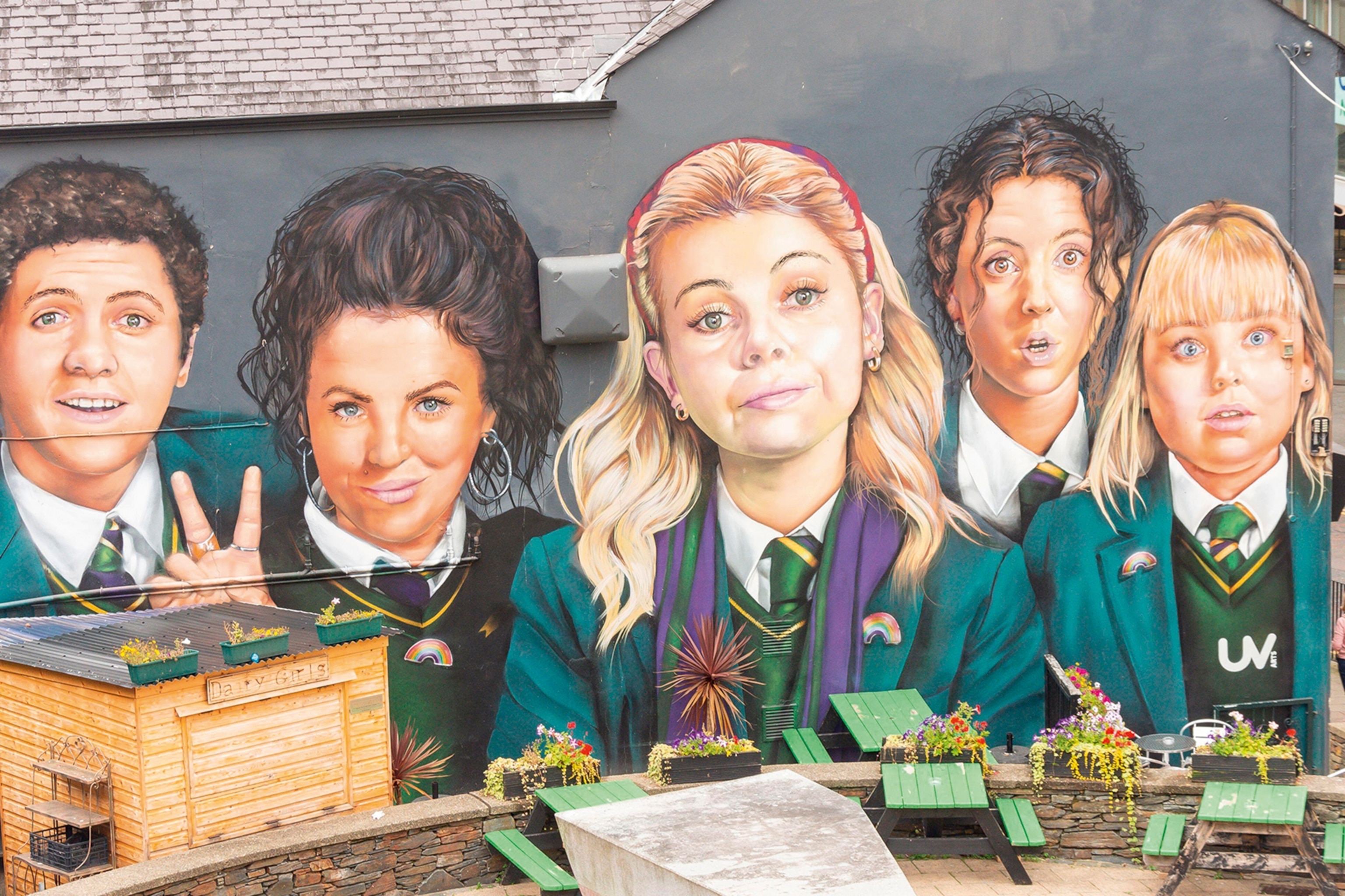 A large painting of the cast of Derry Girls in their school uniforms on the side of a building