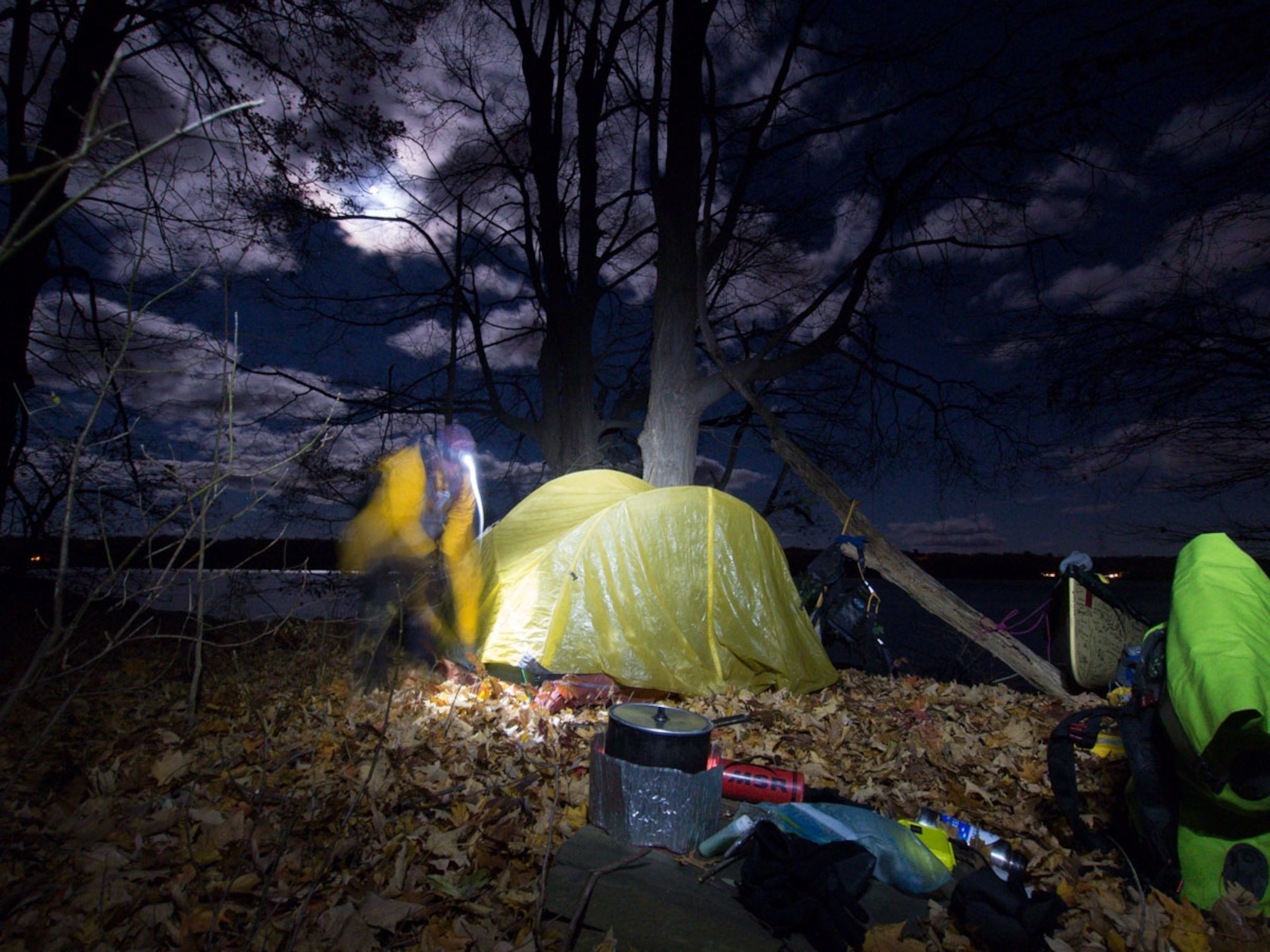 Amy Freeman sets up the tent in the dark along the Hudson River.
