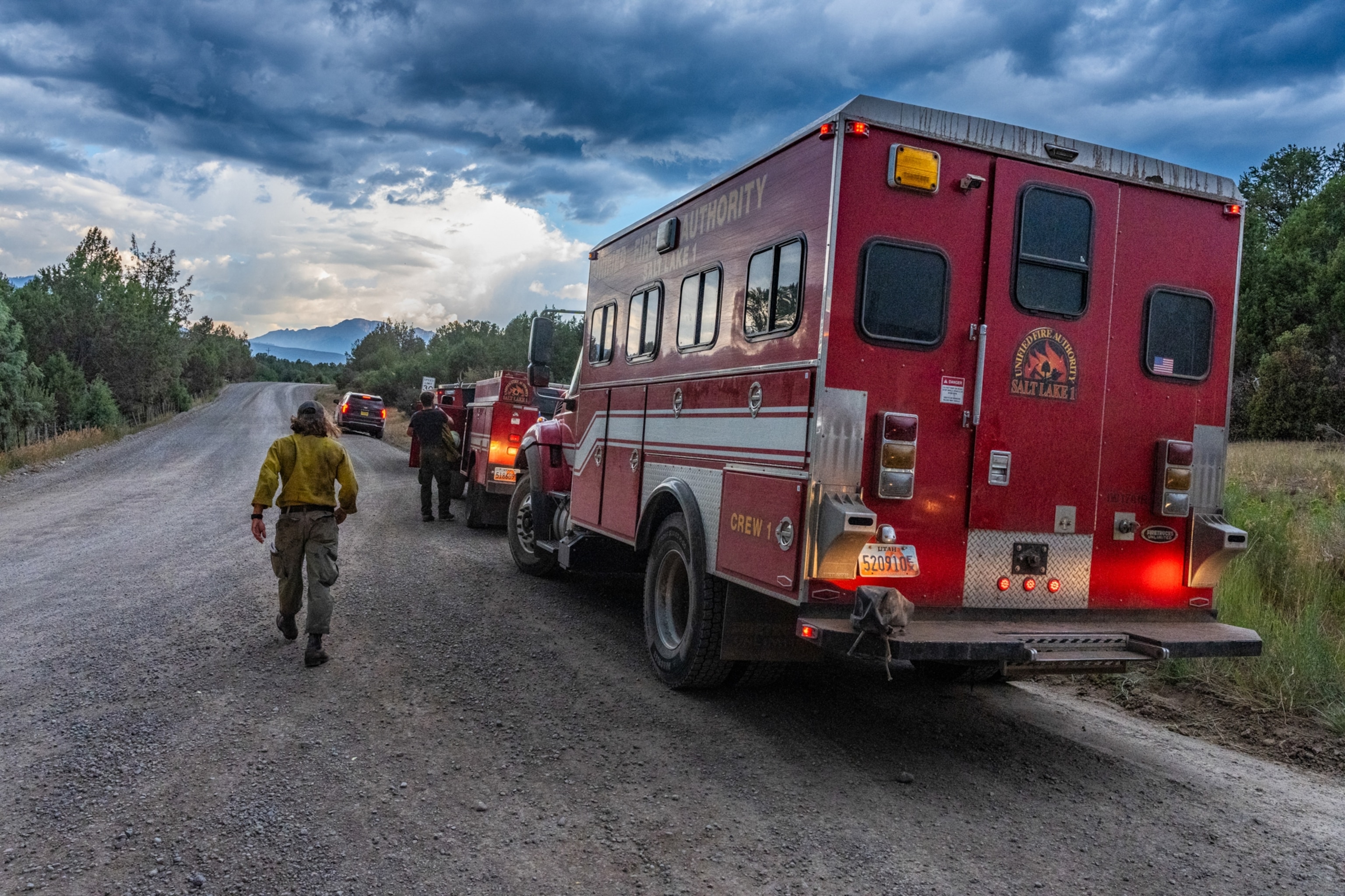 Cameron Sesser walks towards the mountains next to a fire truck.