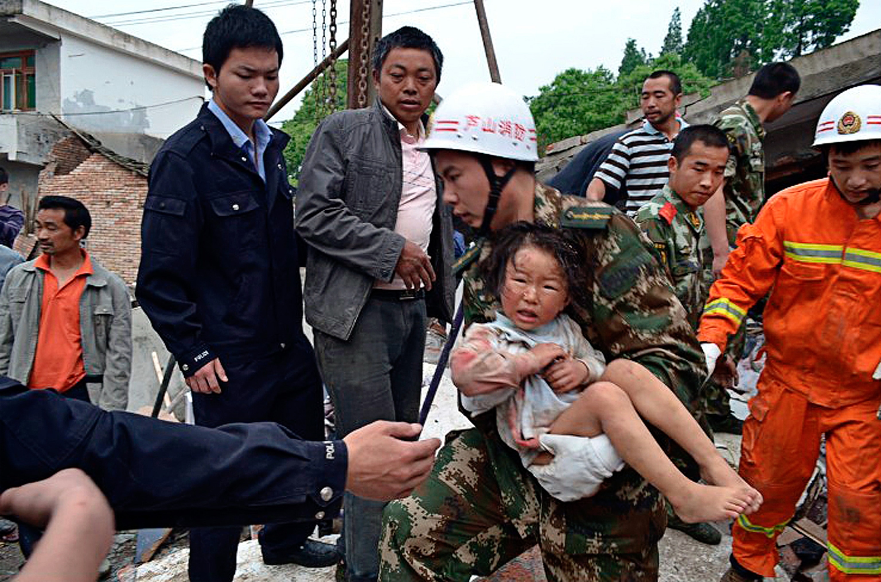 China earthquake picture: A rescuer carries a child to safety